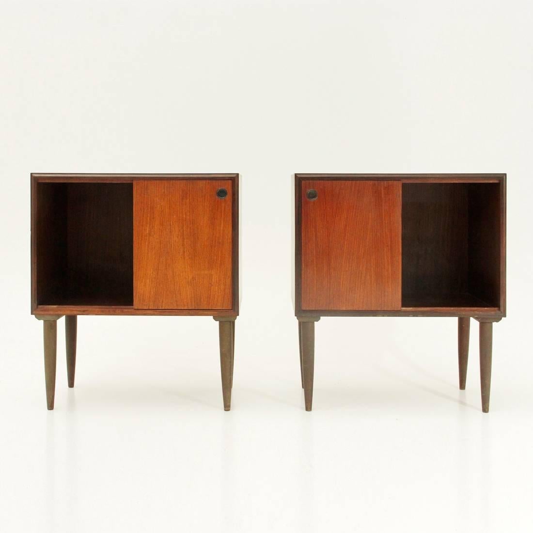 Pair of 1950s bedside tables of Italian manufacture.
Teak veneered wood structure.
Teak-shaped legs in teak.
Compartments with sliding door and circular recessed handle in black painted metal.
Internal drawer.
Excellent general conditions, some