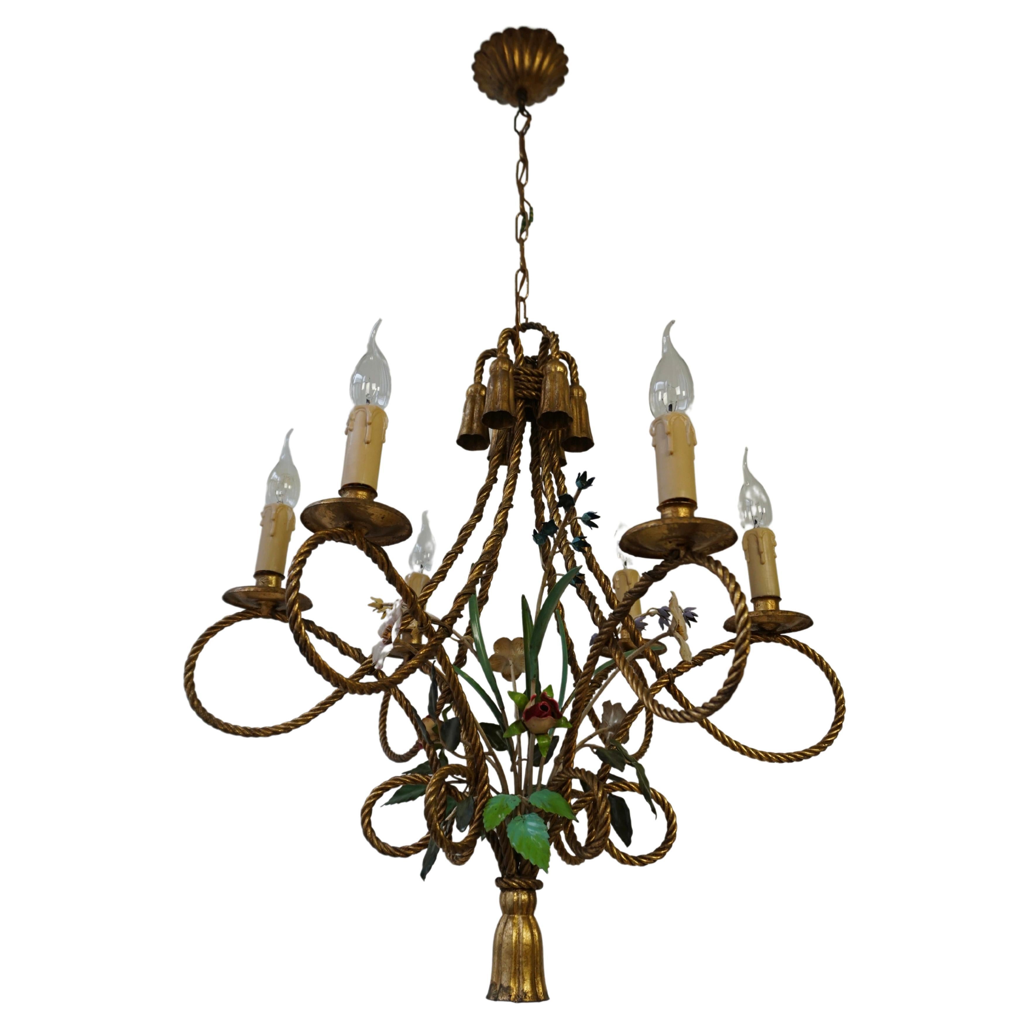 Italian gold-plated metal flower chandelier/tole hanging lamp/tole chandelier.

Unusual dynamic design, consisting of six identical gold-plated metal 'ropes' in a double loop, which come together in a large tassel. The gold-plated metal has acquired