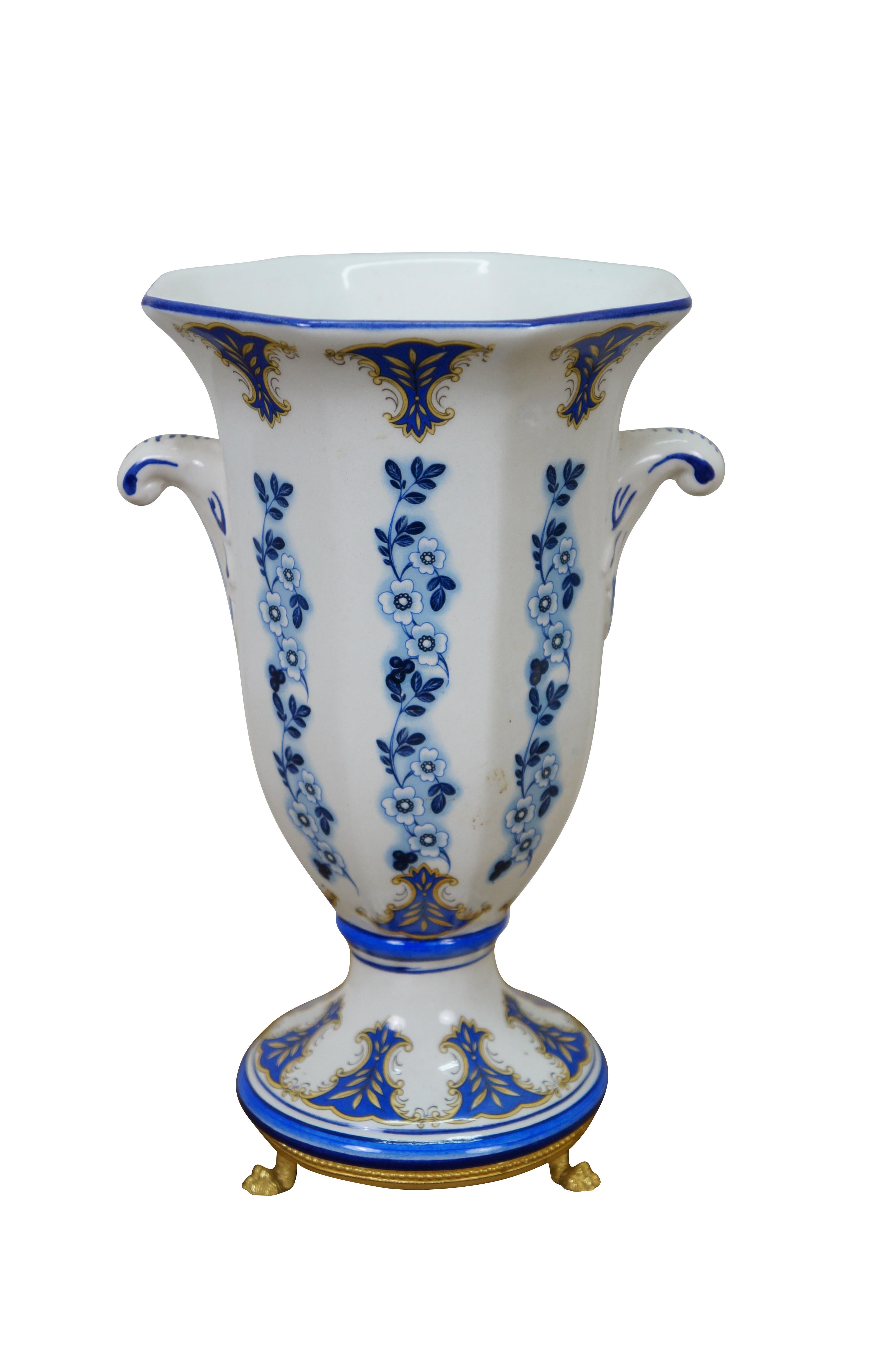 Paire de vases de cheminée sur pied en porcelaine du milieu du XXe siècle, de forme octogonale, décorés de vignes de fleurs de Delft bleu et blanc / motifs de feuillage bleu et or sur le bord et la base, de petites poignées à volutes et de bases en