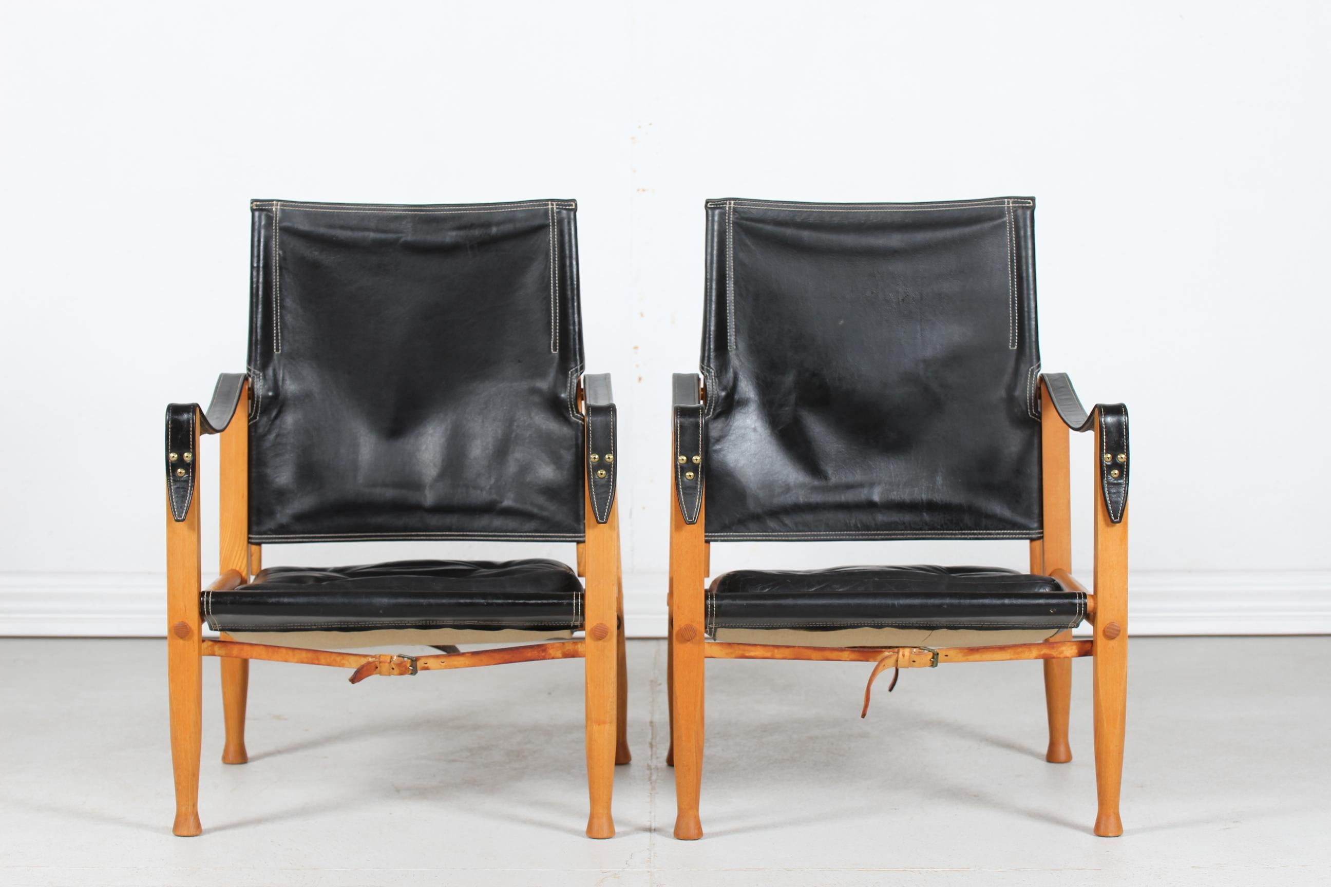 A set of two vintage safari chairs by the Danish architect and furniture designer Kaare Klint (1888-1954) 
Manufactured by cabinetmaker Rud. Rasmussen in Copenhagen.

The frame of the chairs are made of solid ash with cushions and seats of black