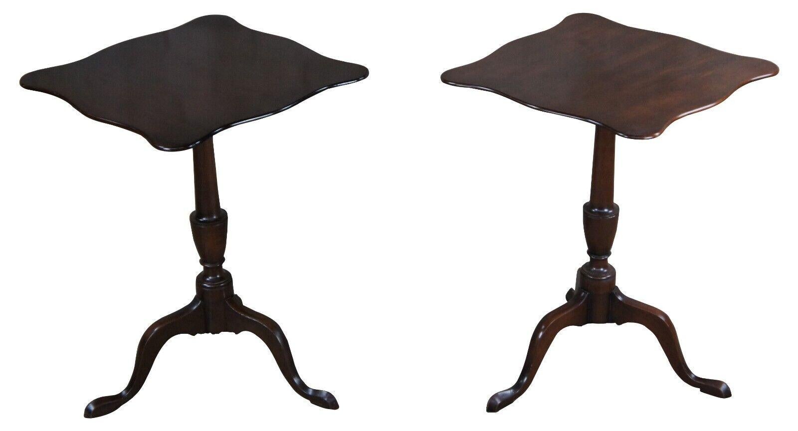 Pair of Federal style mahogany candlestand by Kittinger, circa 1960s. Williamsburg Restoration Line. Features a rectangular top with serpentine edge over a baluster turned base with cabriole legs leading to pad feet.

 Measures: 20