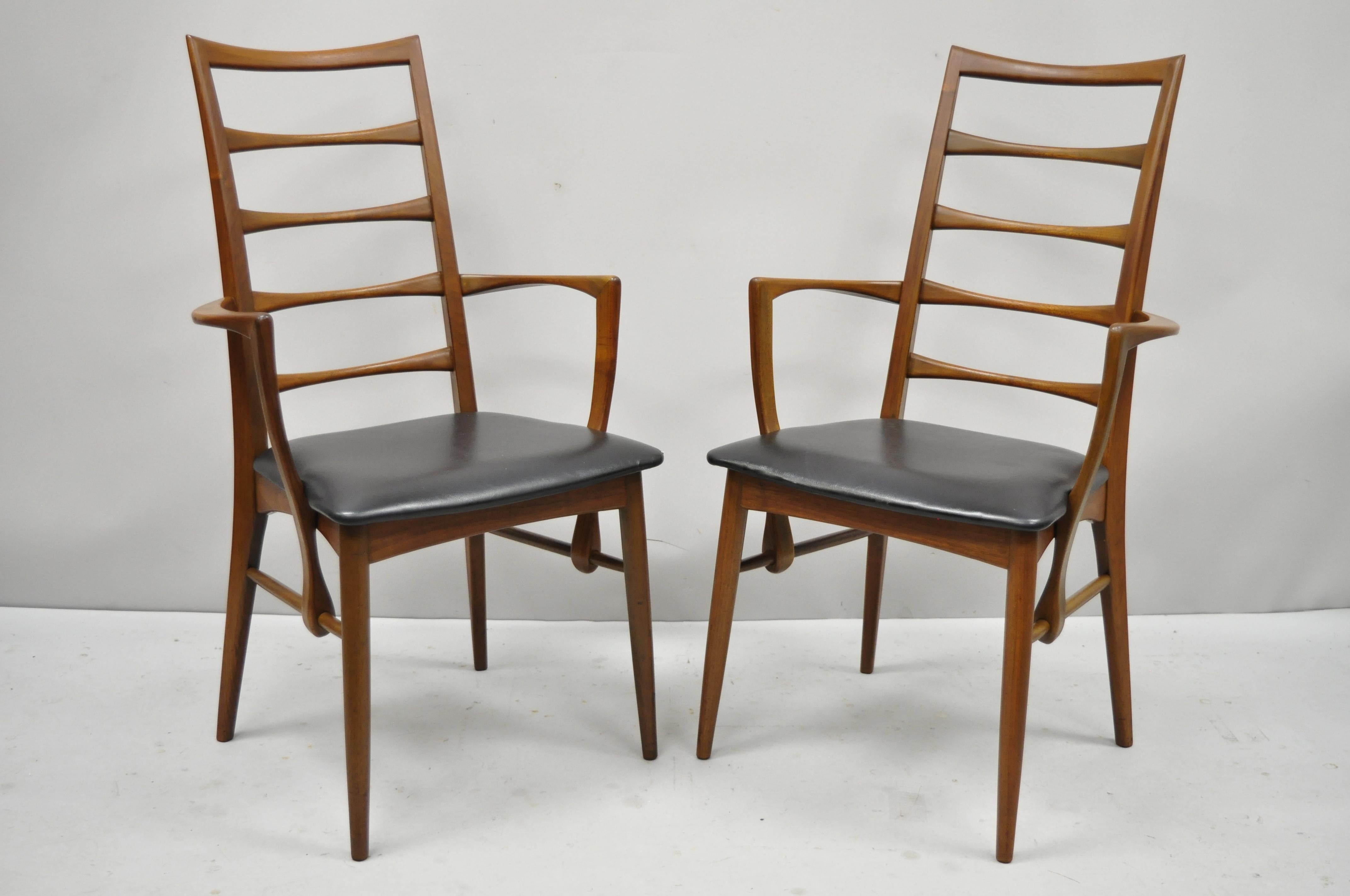 Pair of Koefoed Hornslet midcentury Danish modern teak ladder back dining armchairs. Items feature solid wood construction, beautiful wood grain, original stamp, tapered legs, quality craftsmanship, sleek sculptural form, circa mid-20th century.