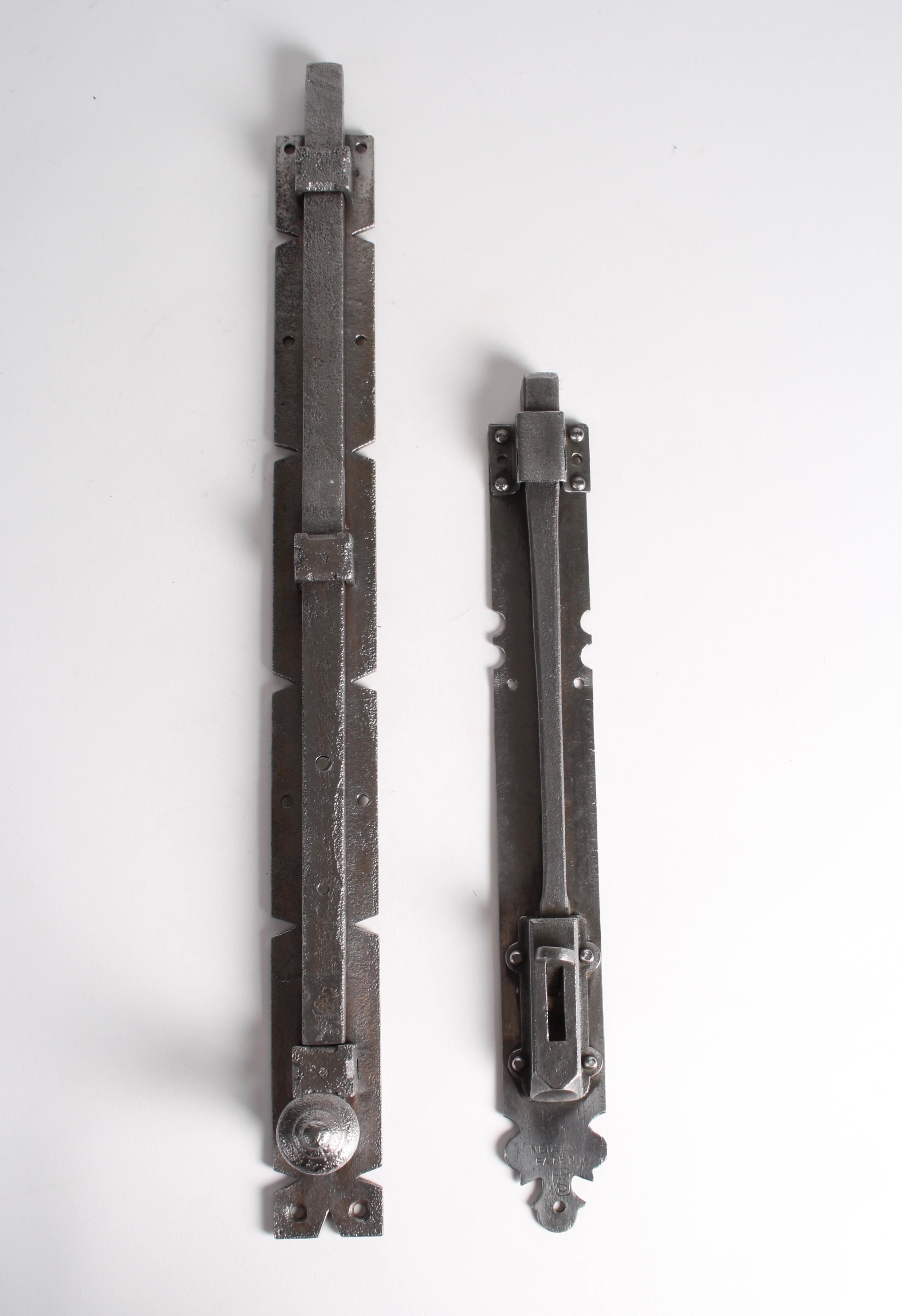 Zwei oberflächenmontierte Türriegel aus Stahl in Übergröße, einer mit der Aufschrift Nielson Patent.

Maße: 16 Zoll und 22 1/2 Zoll.