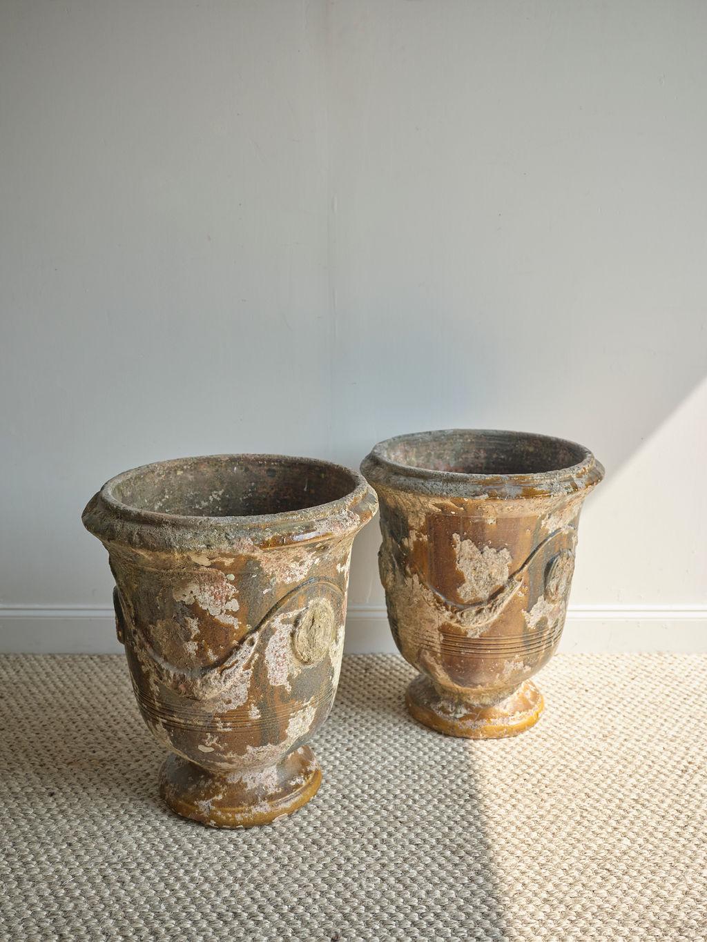These large 19th century urns would make a huge statement in your indoor or outdoor space. They are made out of concrete and finished with some sort of lacquer or paint, which is chipping naturally from age and use. The paint chipping gives these