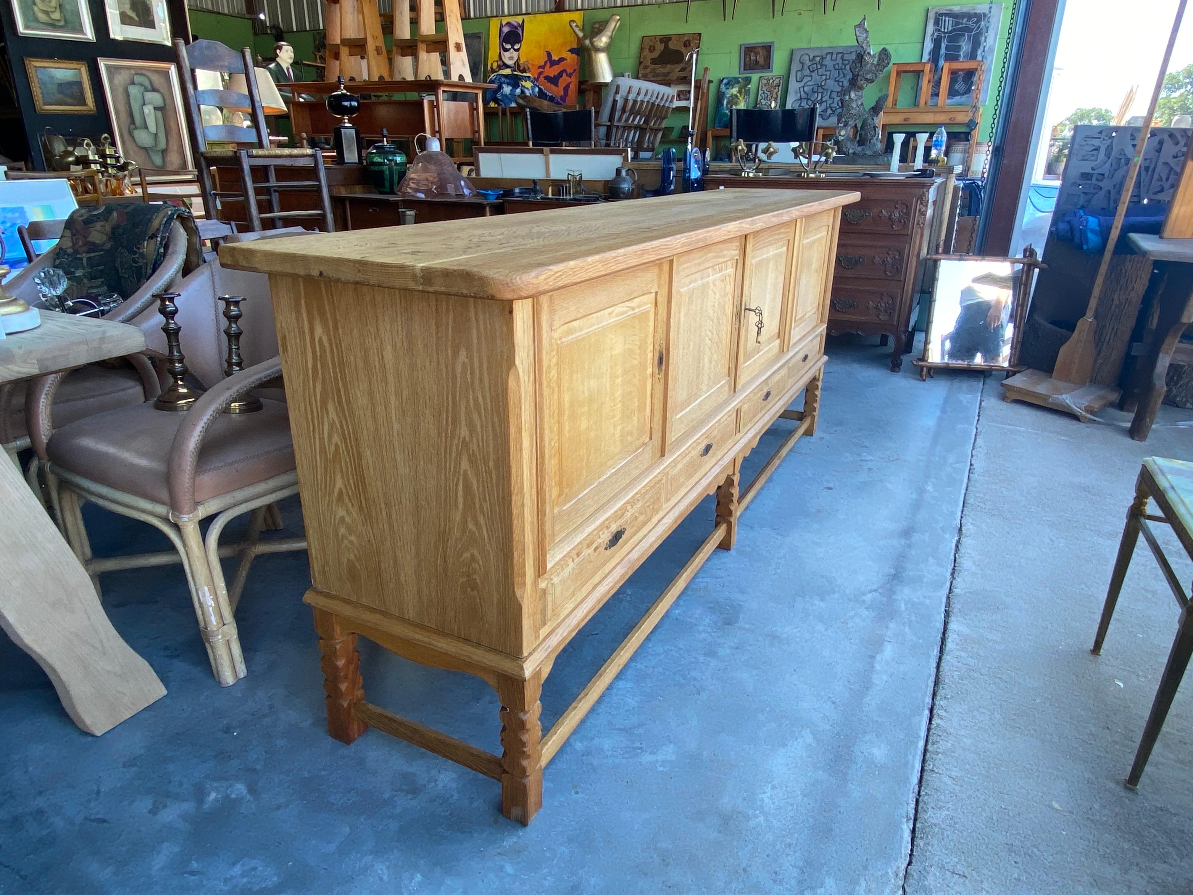 Large Danish oak sideboards, circa 1970s. This brutalist mid-century modern credenza features unique carvings along the legs and base and offers plenty of storage with adjustable shelving. There are two sideboards available.
Dimensions: 89