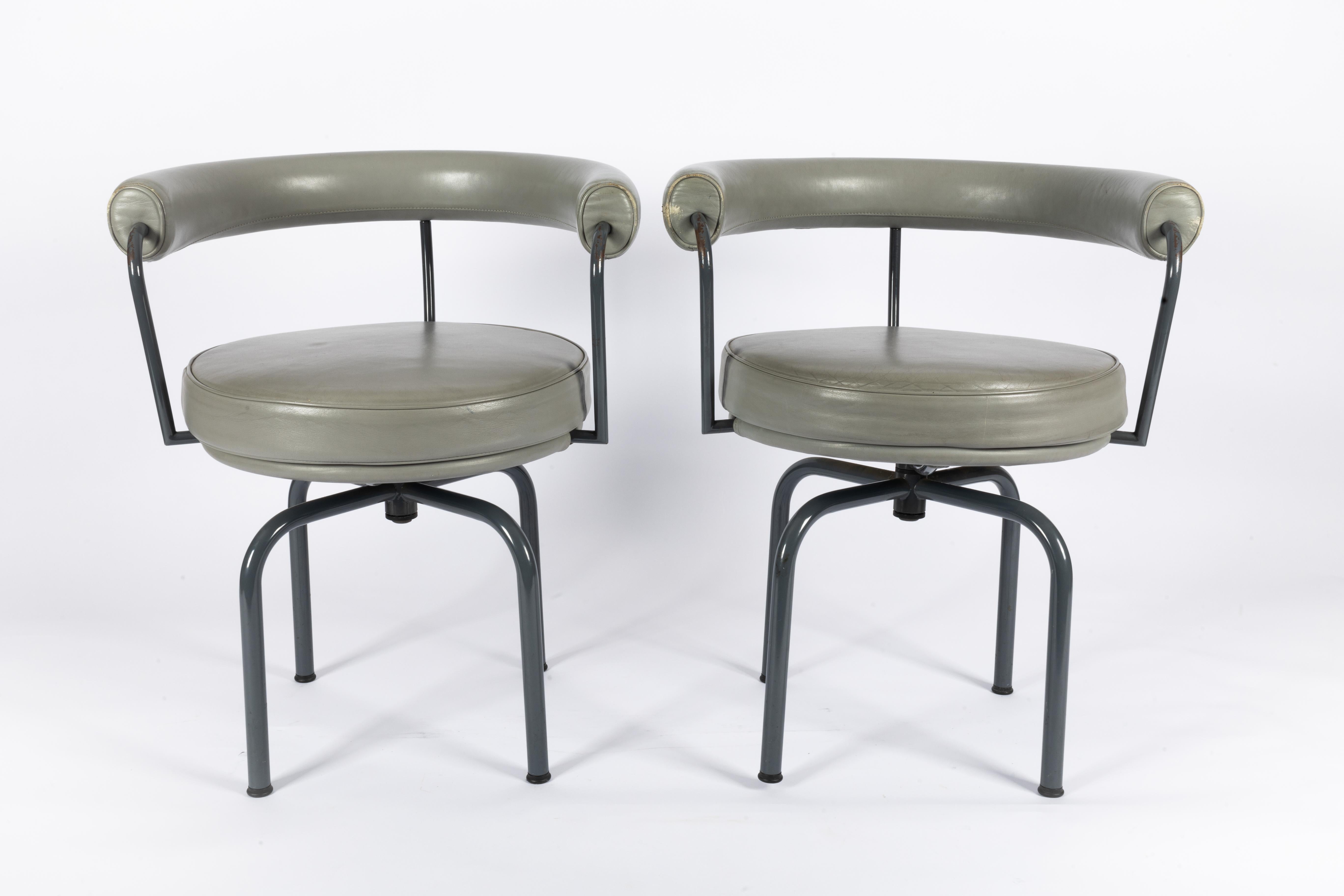 2 chaises pivotantes iconiques LC7 de Charlotte Perriand et Le Corbusier.
Elle a créé ce modèle de chaise en 1927.

Ces deux chaises datent de 1993 et ont été fabriquées par Cassina.

Métal laqué et coussin en cuir.

Le numéro et le fabricant sont