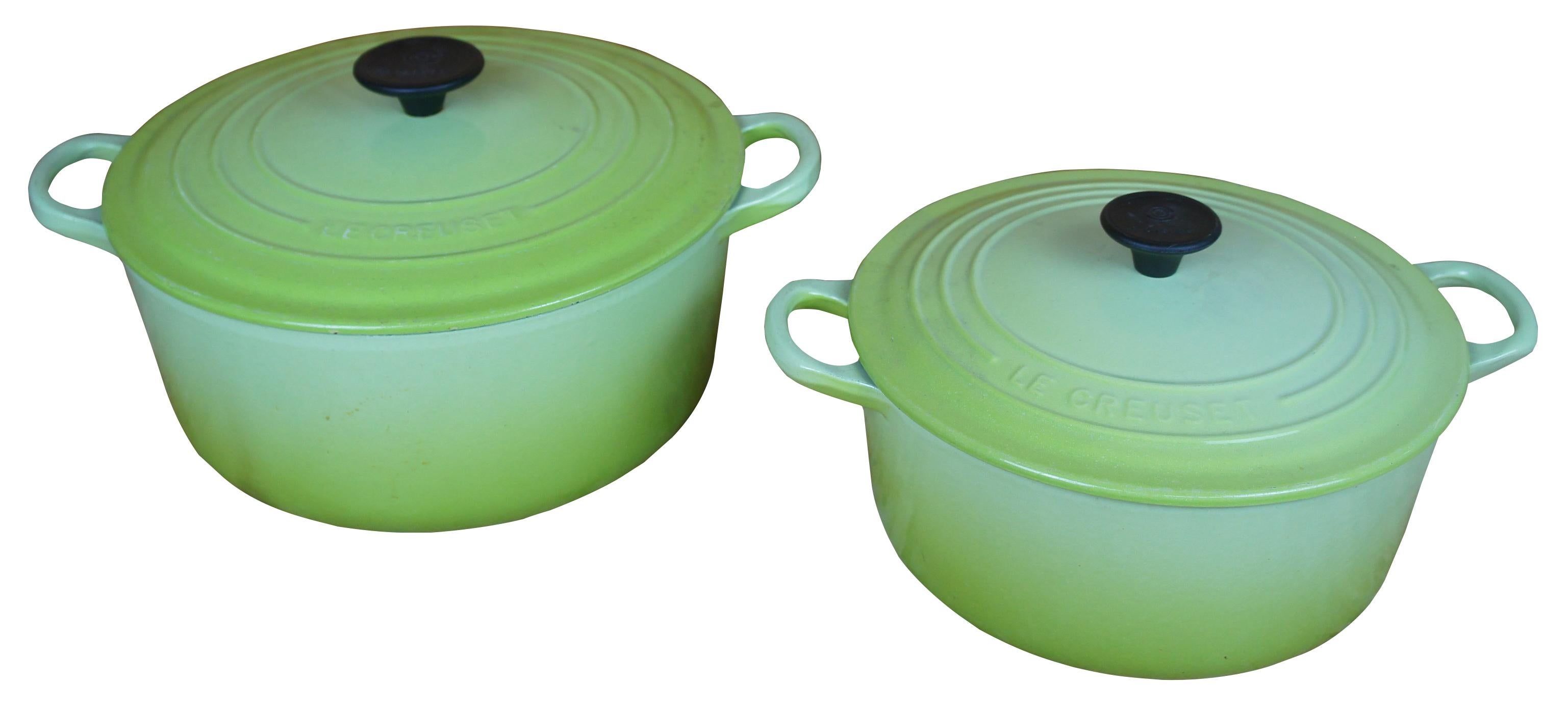 Pair of Le Creuset cast iron and enamel in green, one 5.5 quarts and one 3.5 quarts round dutch ovens with lids.
 