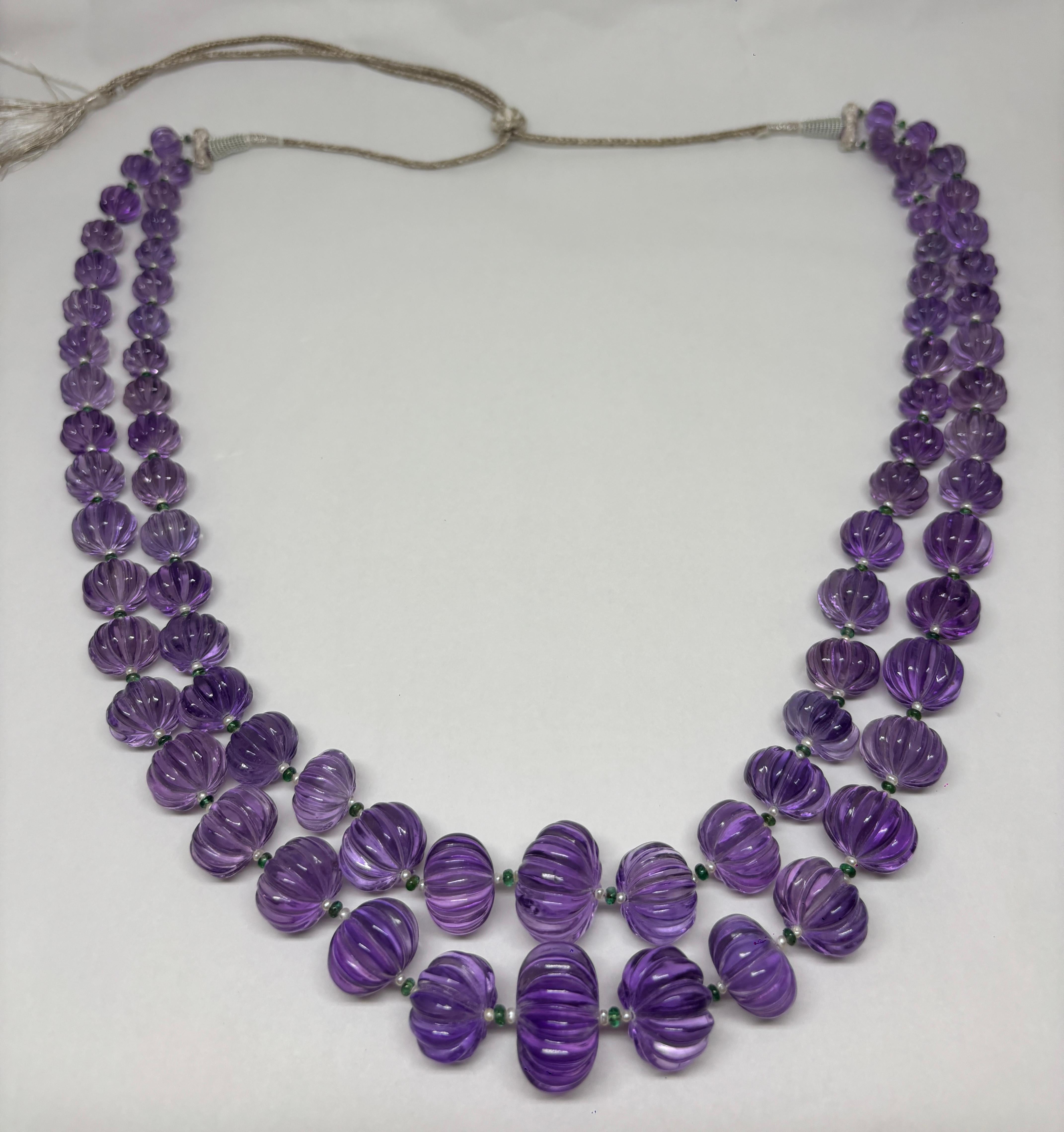 Gefertigt aus 1.350 Karat kunstvoll geschnitzten Amethysten aus Afrika, ergänzt durch 34,15 Karat Smaragde und Perlen. 

Der tiefe violette Farbton der Amethyste verkörpert Ruhe und Eleganz, während die Smaragde eine lebendige grüne Energie