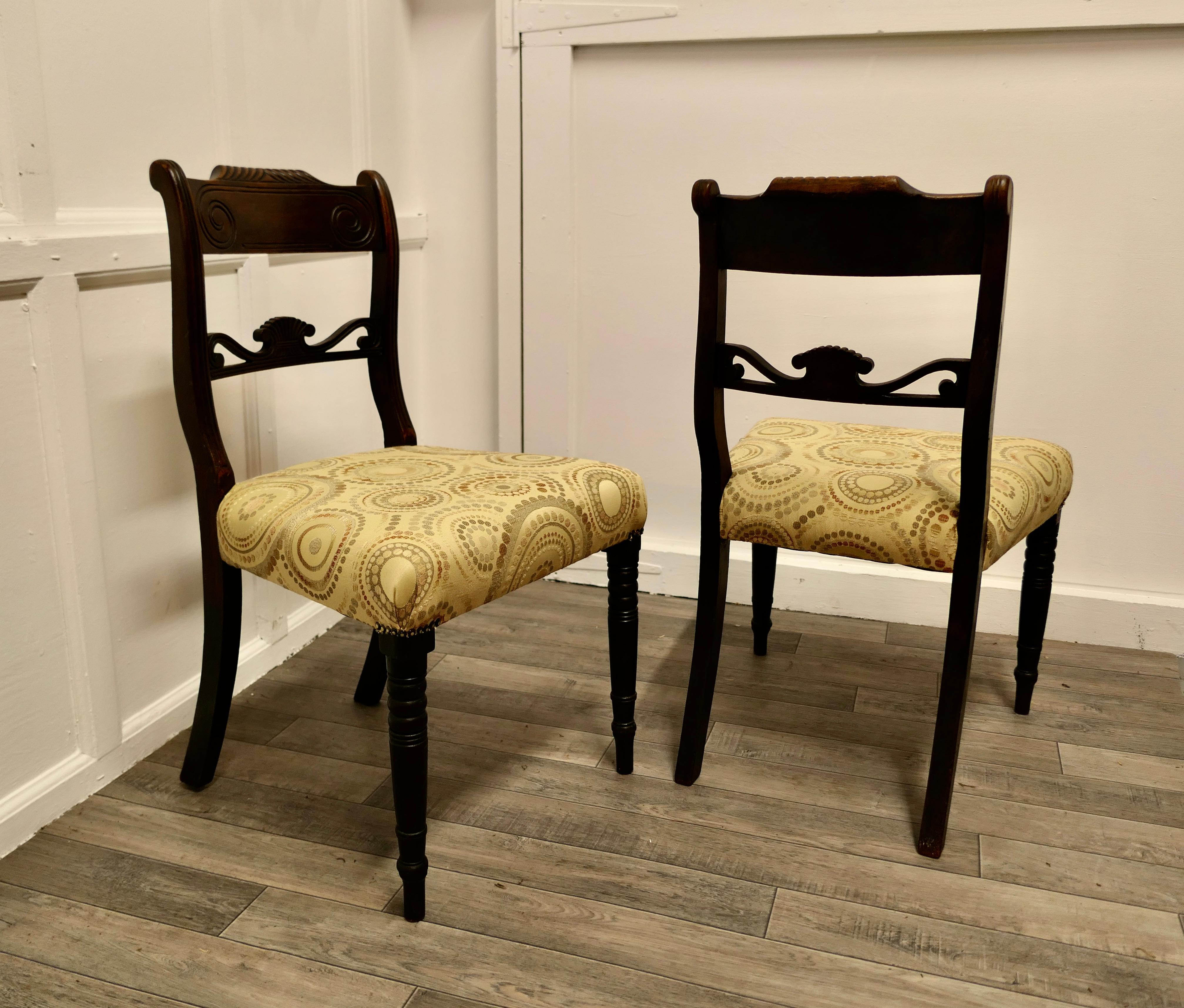 2 Lovely Regency chairs with new Upholstered seats 
 
A very attractive pair of chairs, they have a broad carved back top rail and a carved centre rail
The chairs have slender turned legs and the seats have new Silk upholstery in tones of cream