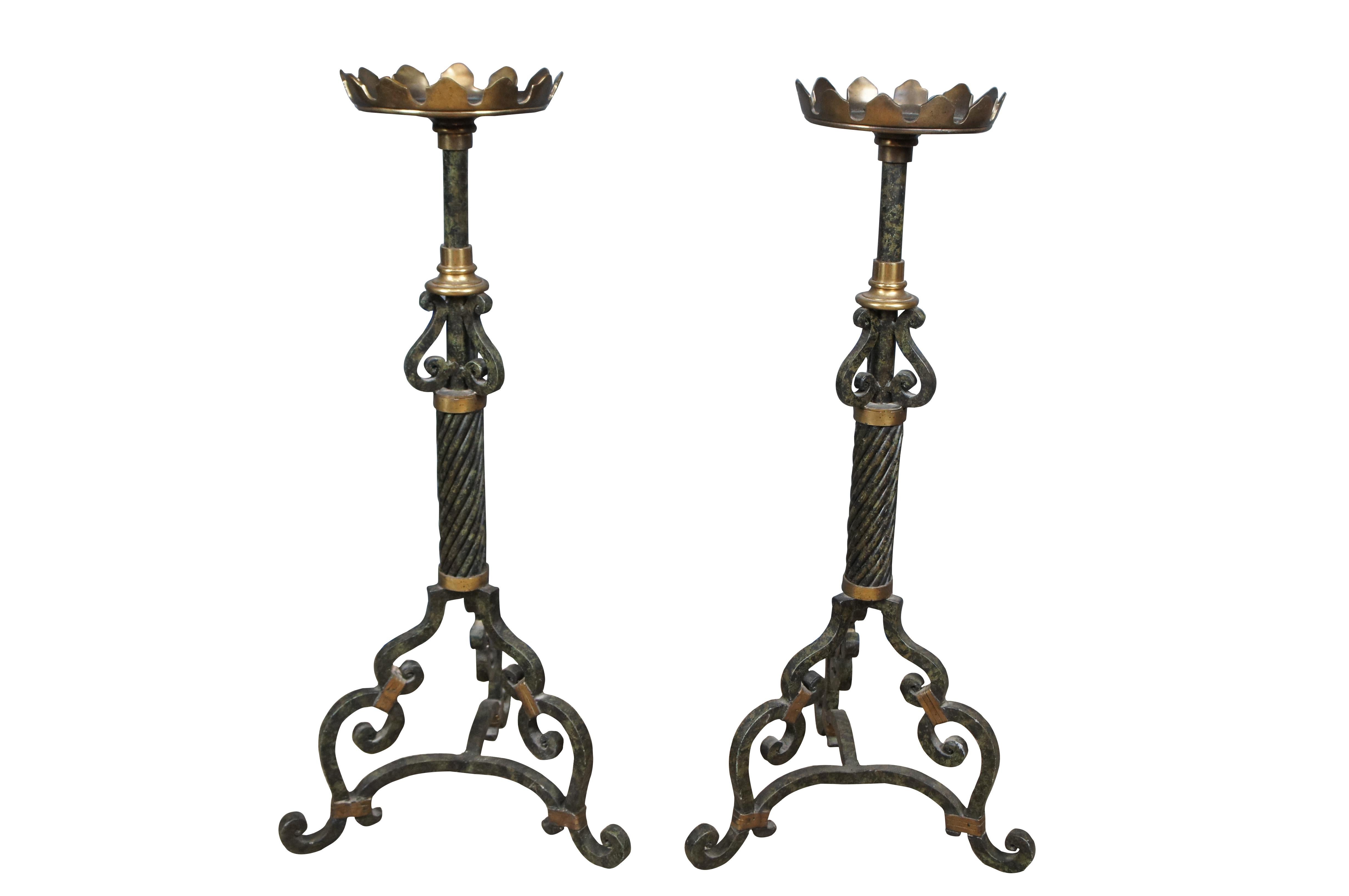 An exquisite pair of large scrolled iron and brass pricket / candle sticks by Maitland Smith. Features a faux marbled finish with large drip pan for wax collection. A stately pair with twisted center and 