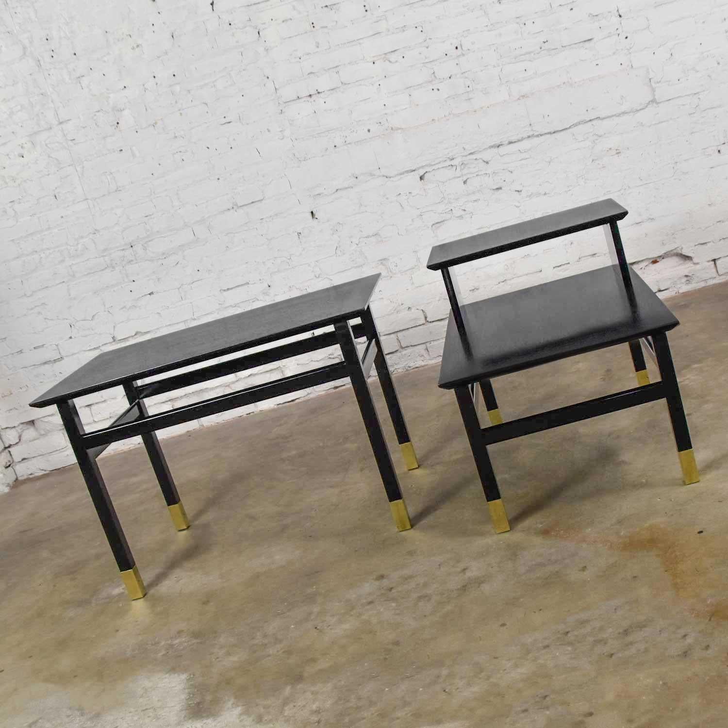 Wonderful pair of vintage mid-century modern side tables or end tables. One straight table and one step table from the Coronado Group by Luther Draper for Founders Furniture comprised of hardwood, brass sabots, and black satin painted finish.