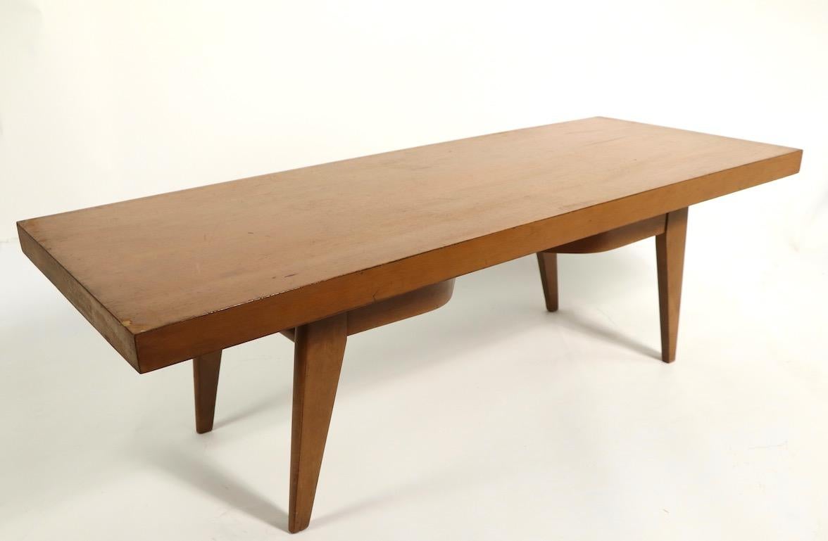 Interesting coffee table having an undercarriage which can be placed in several positions beneath the rectangular top. We have a pair of these to offer, priced and available individually, but we would love to see them stay together. Both tables show
