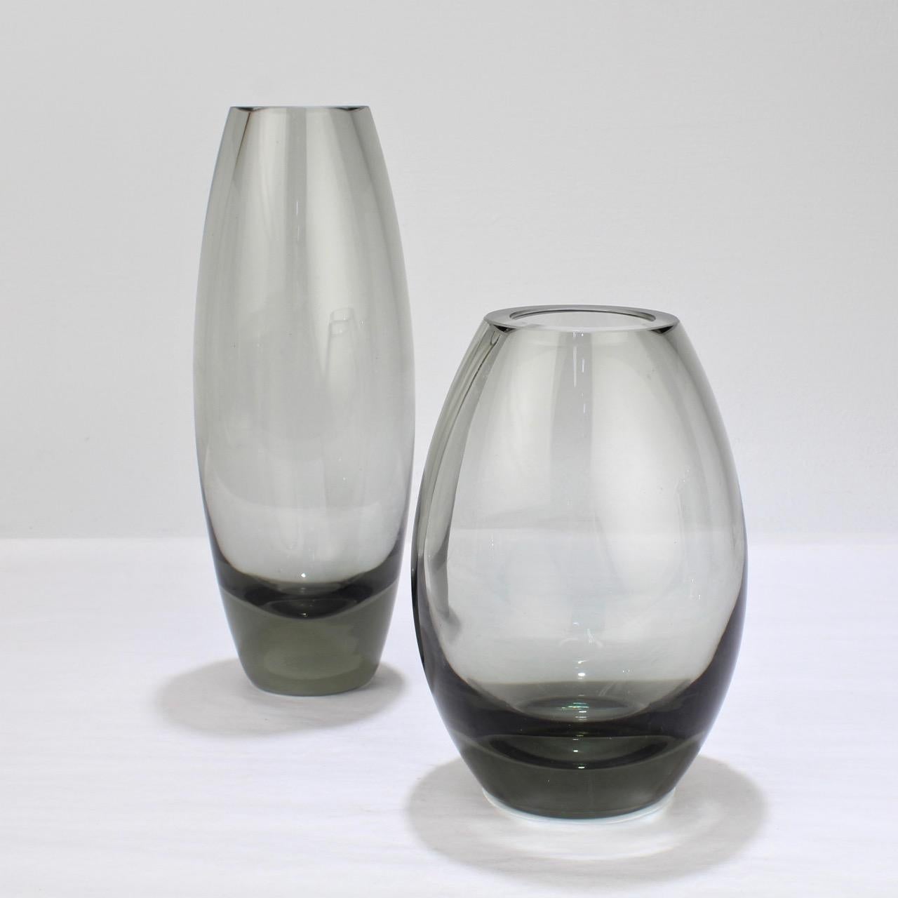 A terrific assembled pair of Hellas vases in grey.

Designed by Per Lutken for Holmegaard Glass. 

Each bases bears an etched mark for Holmegaard, 1956 and Per Lutken's monogram.

The crisp, clean lines of the vases speak directly to the