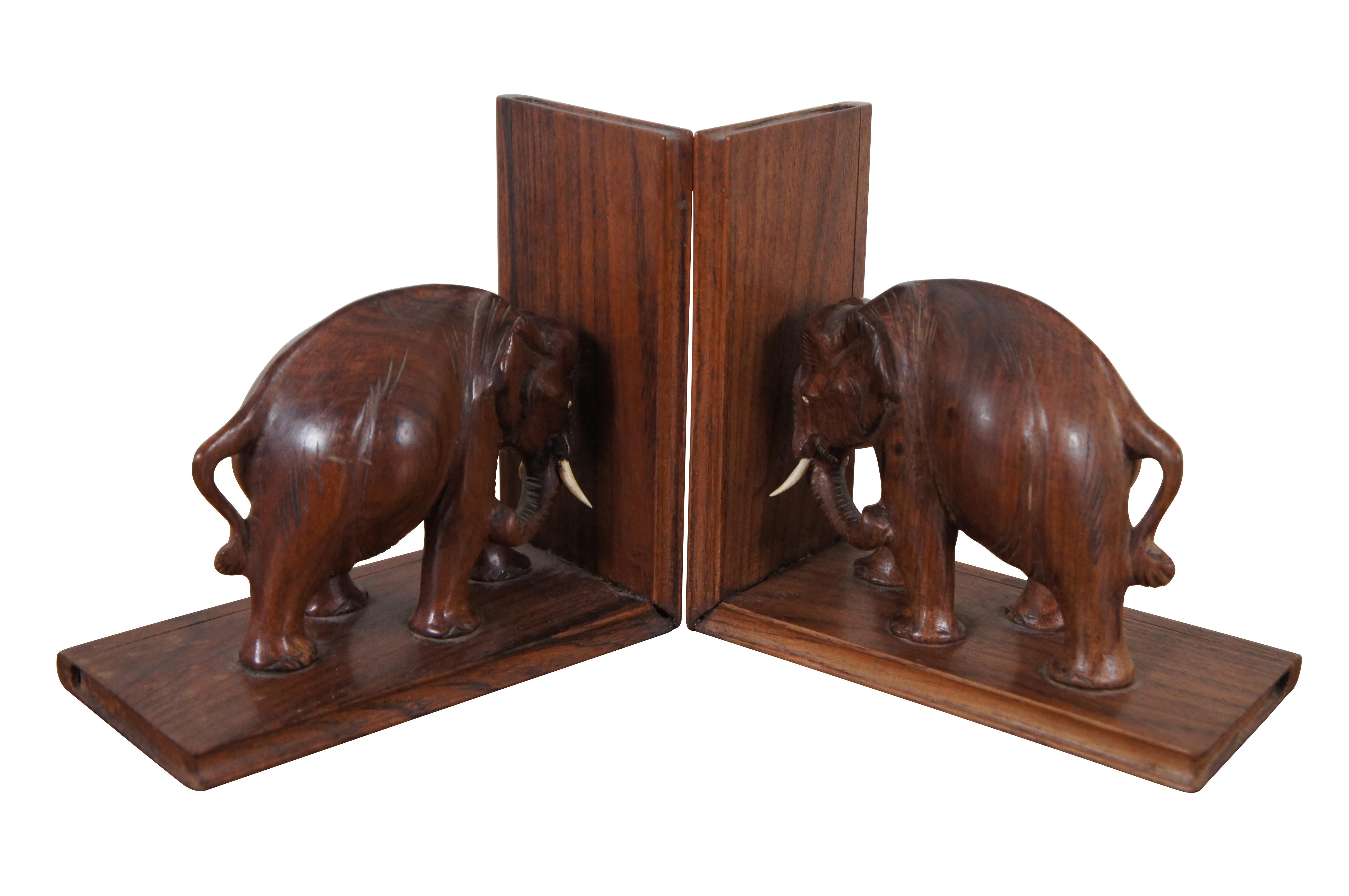 Pair of mid 20th century hand carved Rosewood bookends featuring African elephants with inlaid eyes and tusks, standing on book shaped panels.

Dimensions:
6.5