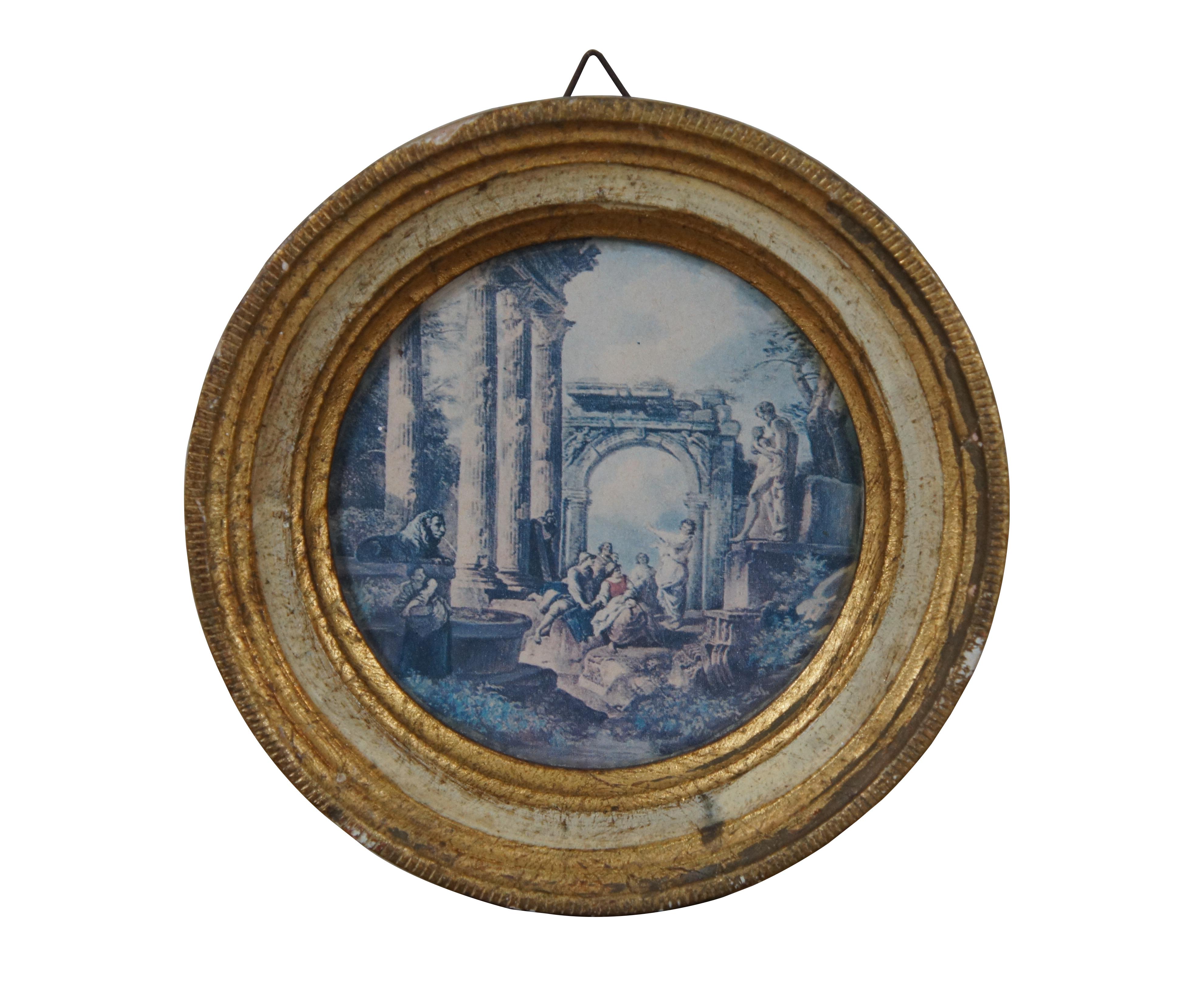 Pair of mid century small, round prints of  scenes of Roman ruins with figures by Gian Paolo Panini. Framed in distressed gold / gilt and white frames. The one with the lion fountain identified specifically as “Homily of an Apostle in Roman Ruins.”