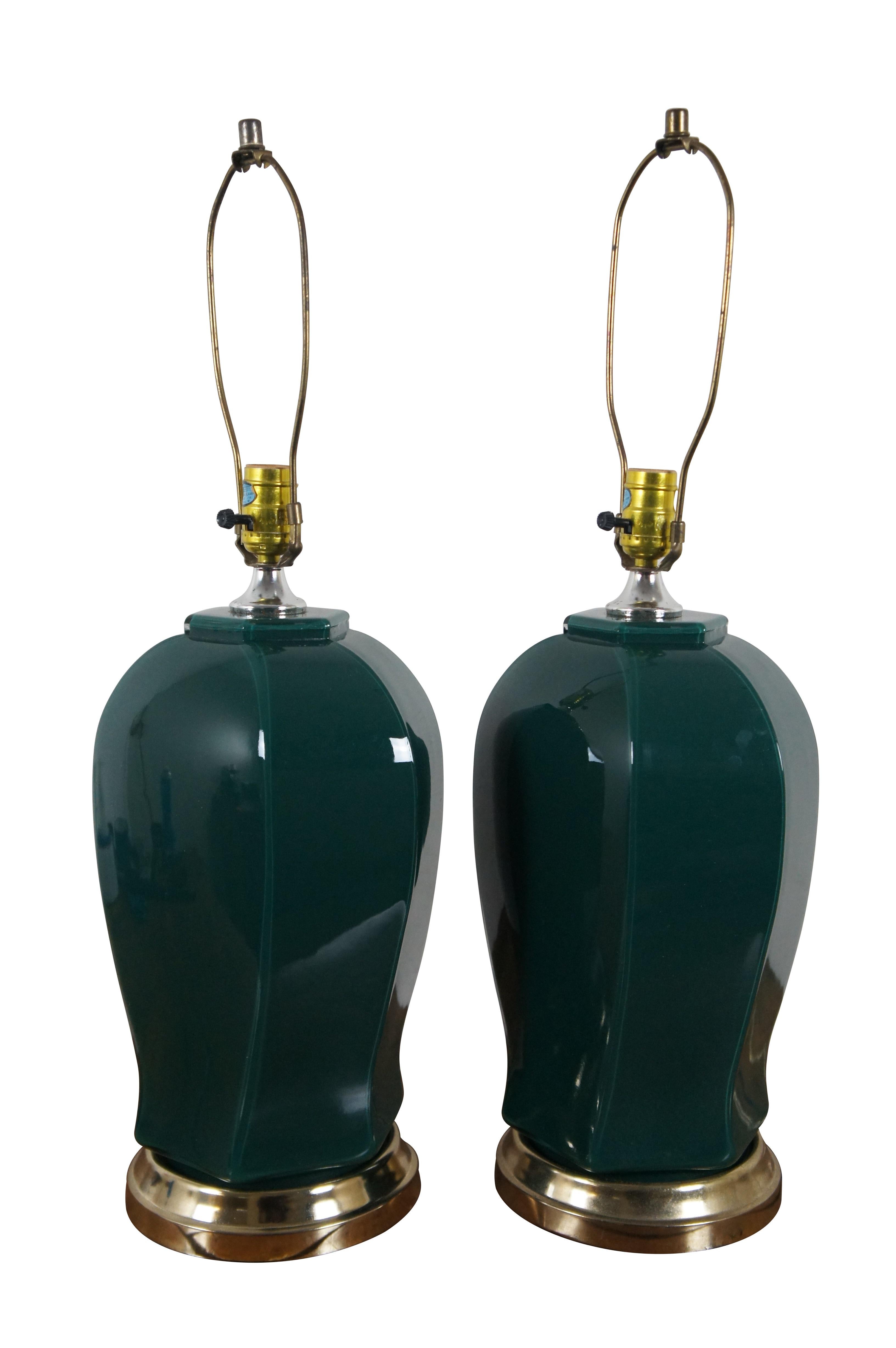 Pair of mid 20th century glass table lamps, reverse painted in forest green featuring brass bases and a unique faceted ginger jar / urn shaped body. Includes harp and simple cap shaped finials.

Dimensions:
10