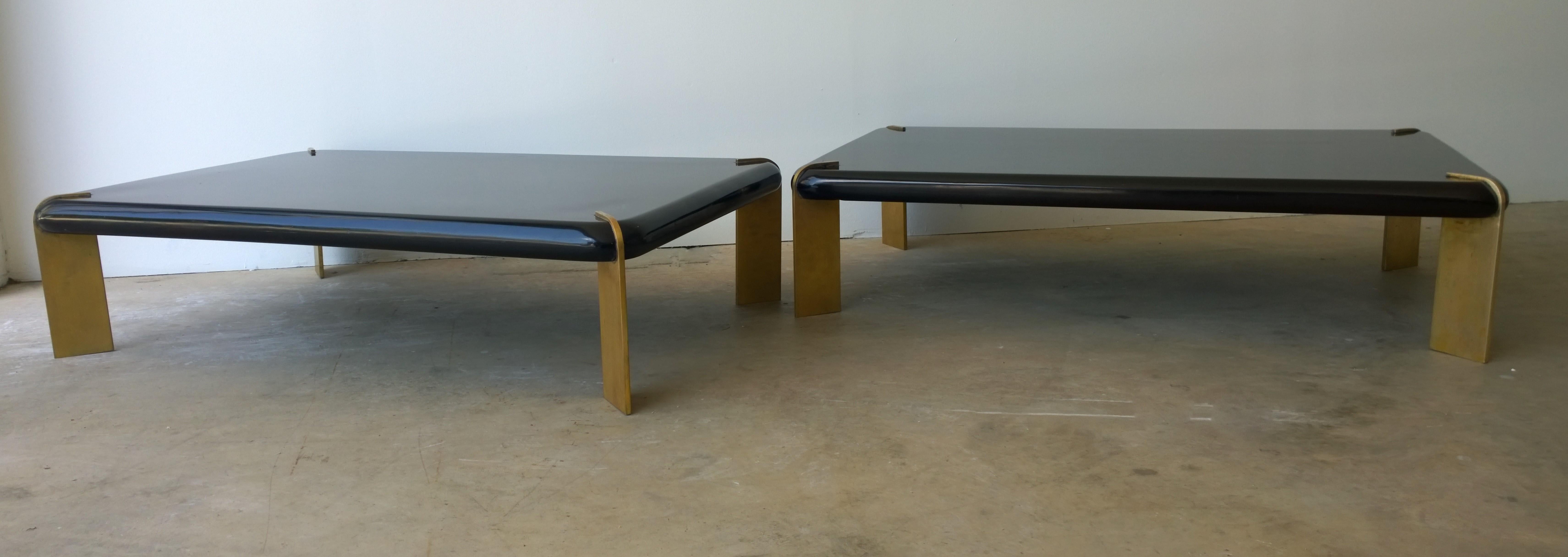 Offered are two Mid-Century Modern French coffee / cocktail tables lacquered in black with four substantial bronze legs. These unique coffee / cocktail tables are quite dramatic albeit with very clean lines and modern design. The substantial and