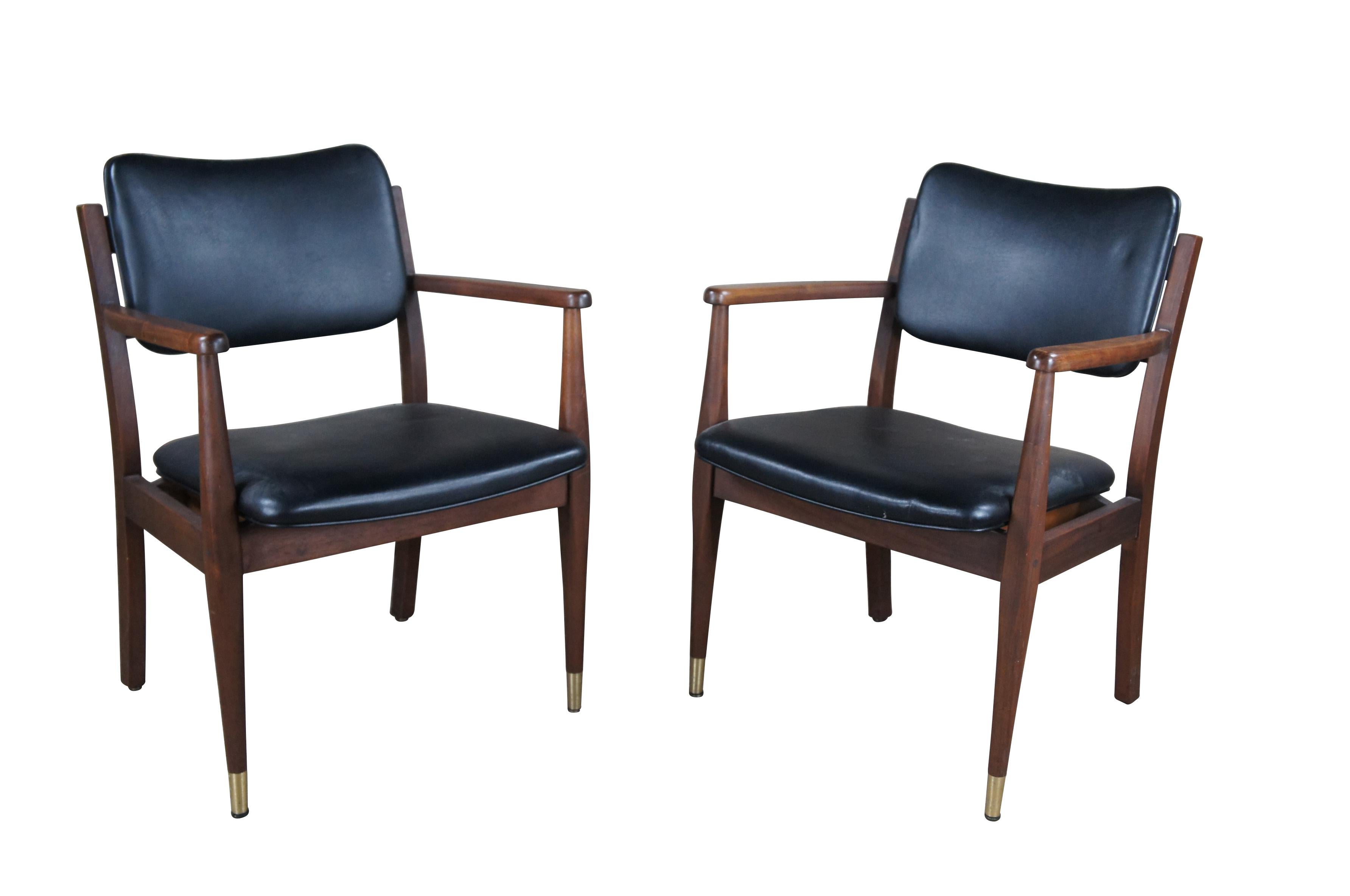 Pair of vintage Gregson Furniture Industries Danish style Arm Chairs, circa 1983.  Made of walnut with black leather seat and back.  Features nailheads along the backside.  

Gregson Furniture Industries, Liberty North Carolina was founded in 1921