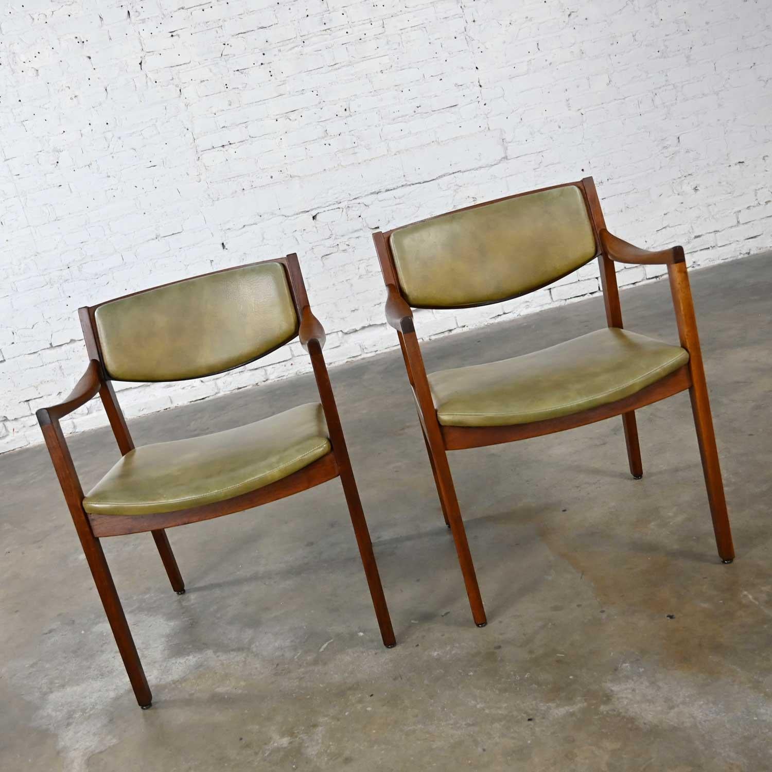 Awesome mid-century modern solid walnut and original olive-green faux leather armchairs by Gunlocke. Beautiful condition, keeping in mind that these are vintage and not new so will have signs of use and wear. These chairs have been freshly stained