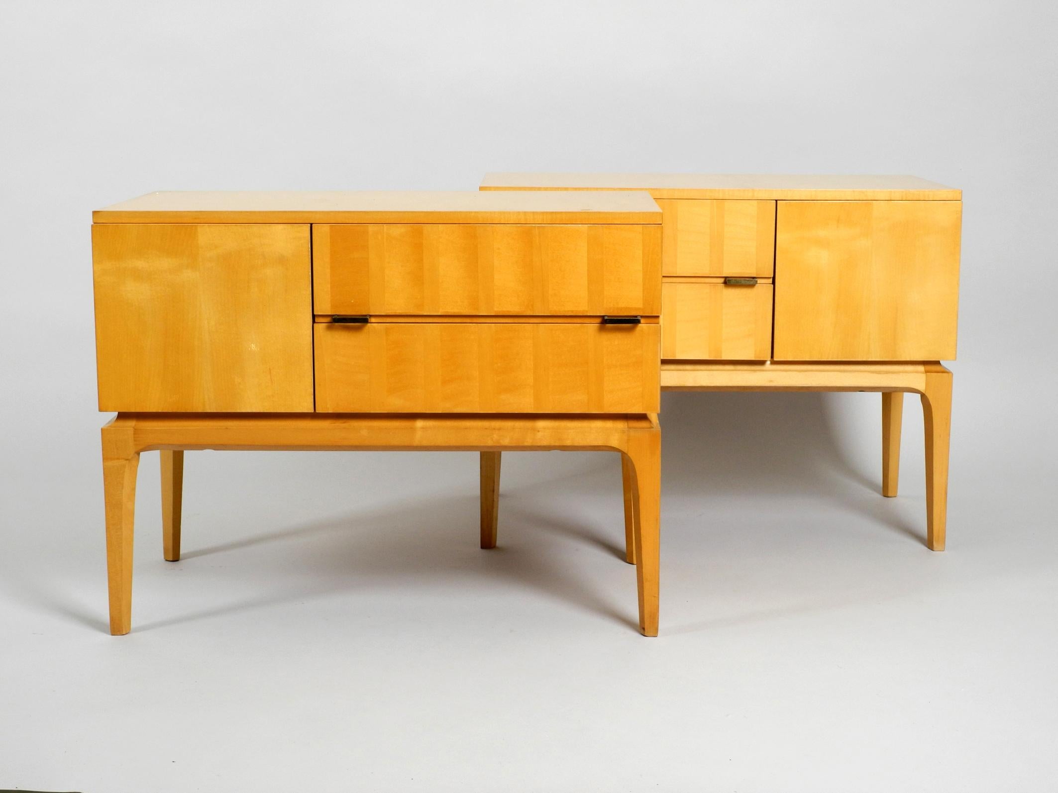 Two beautiful 1950s maple wood nightstands with clear lacquer. 
Typical midcentury design in very good vintage condition, probably never used. 
Inside the drawers they are like new.
With two drawers and a folding compartment. Both open and close