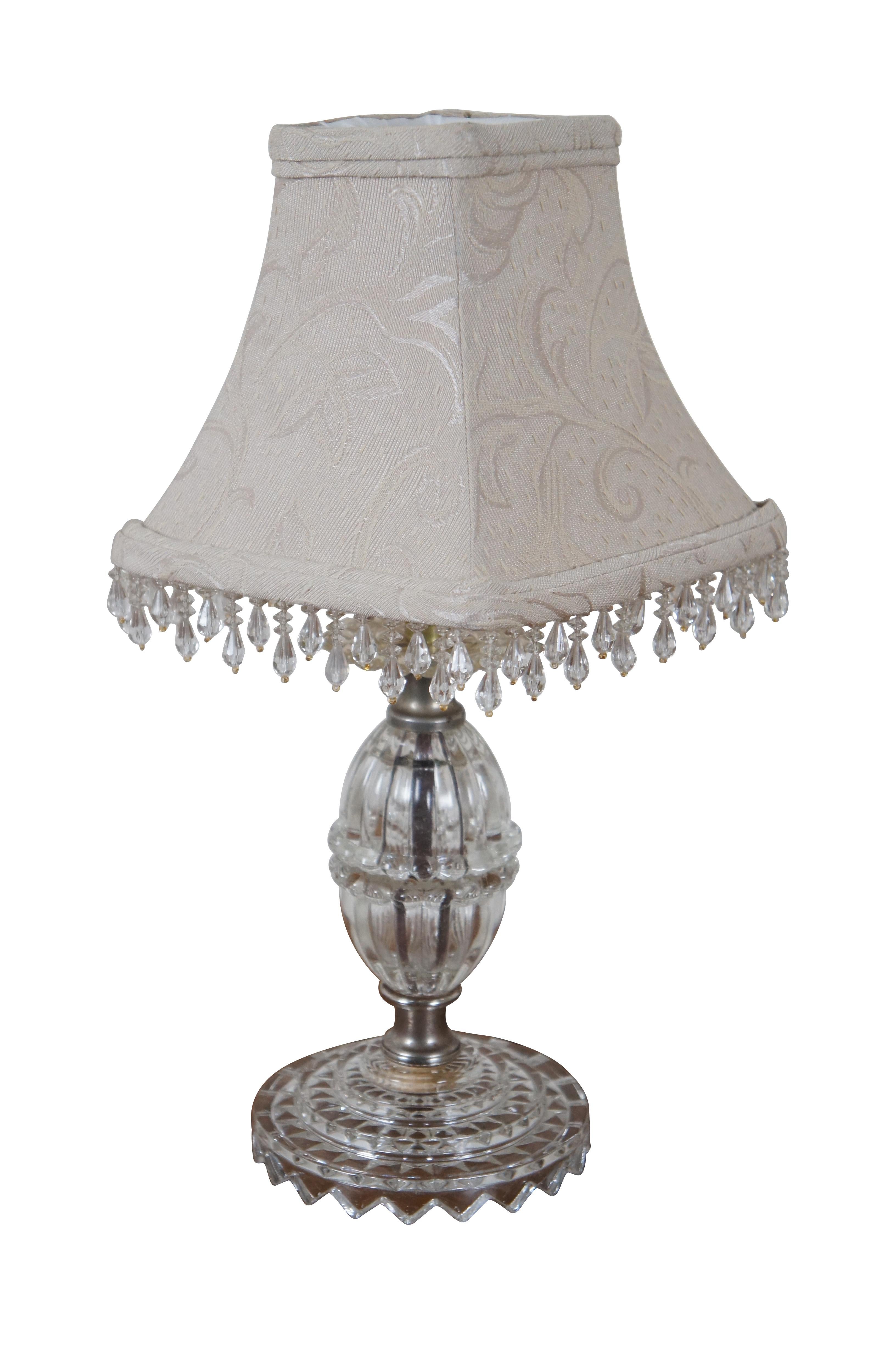 Pair of petite pressed glass Hollywood Regency budoir / table lamps circa mid 20th century, featuring tiered round sawtooth bases, fluted almond shaped body with bubble edge around the middle and topped with a bubble edge “drip catcher.” Lamps