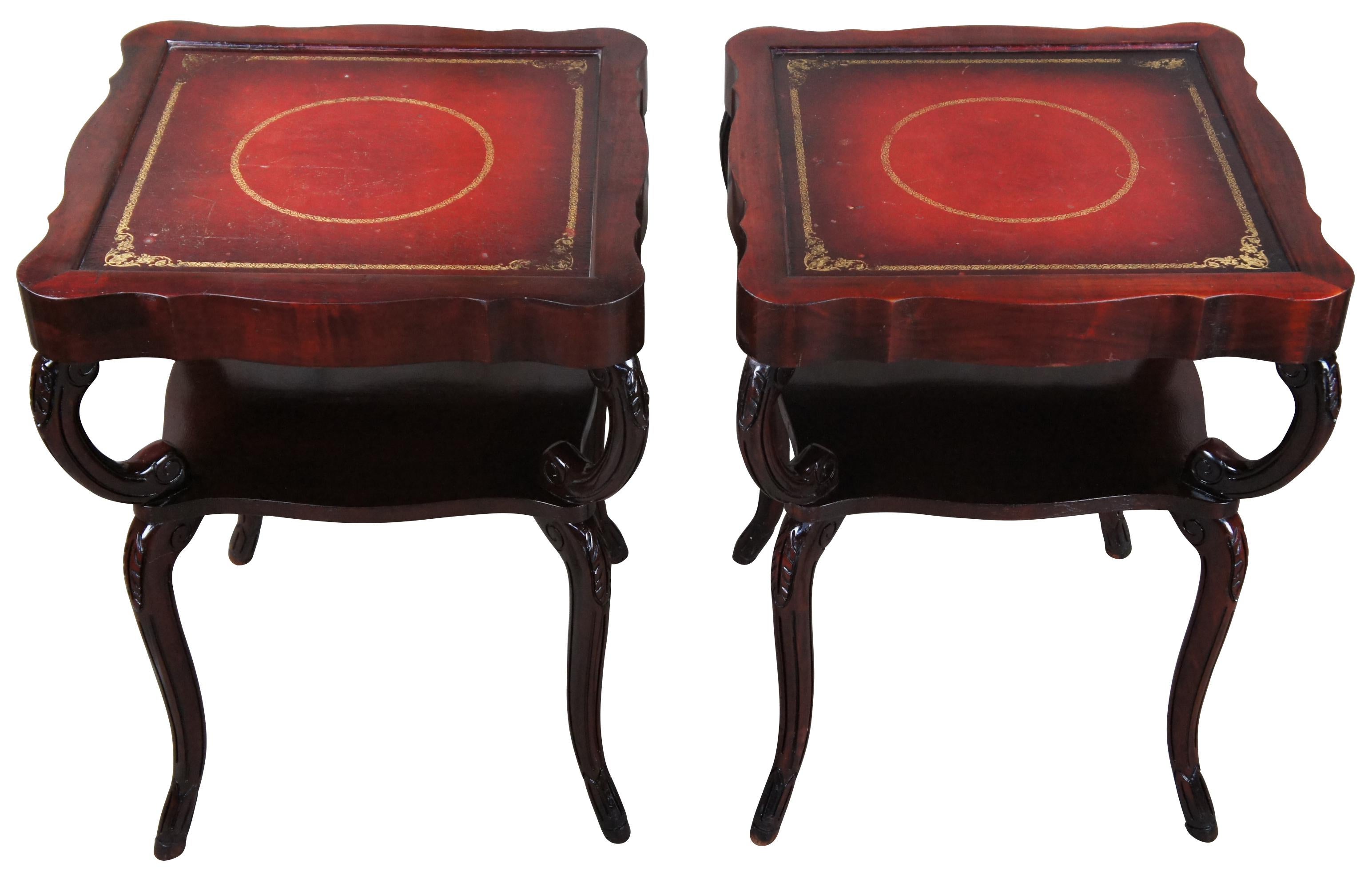 A stunning pair of Regency tiered side tables, circa 1940s. Made from mahogany with a serpentine shaped square tooled leather red top supported by carved 