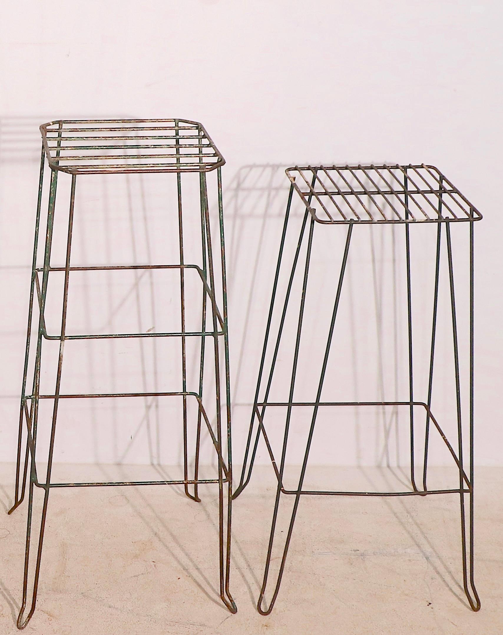Offering two wire, or wrought iron, plant stands, both are structurally sound and sturdy, both show cosmetic wear to finish, normal and consistent with age. The plant stands are green, although they may appear black in some of the images. 
 The
