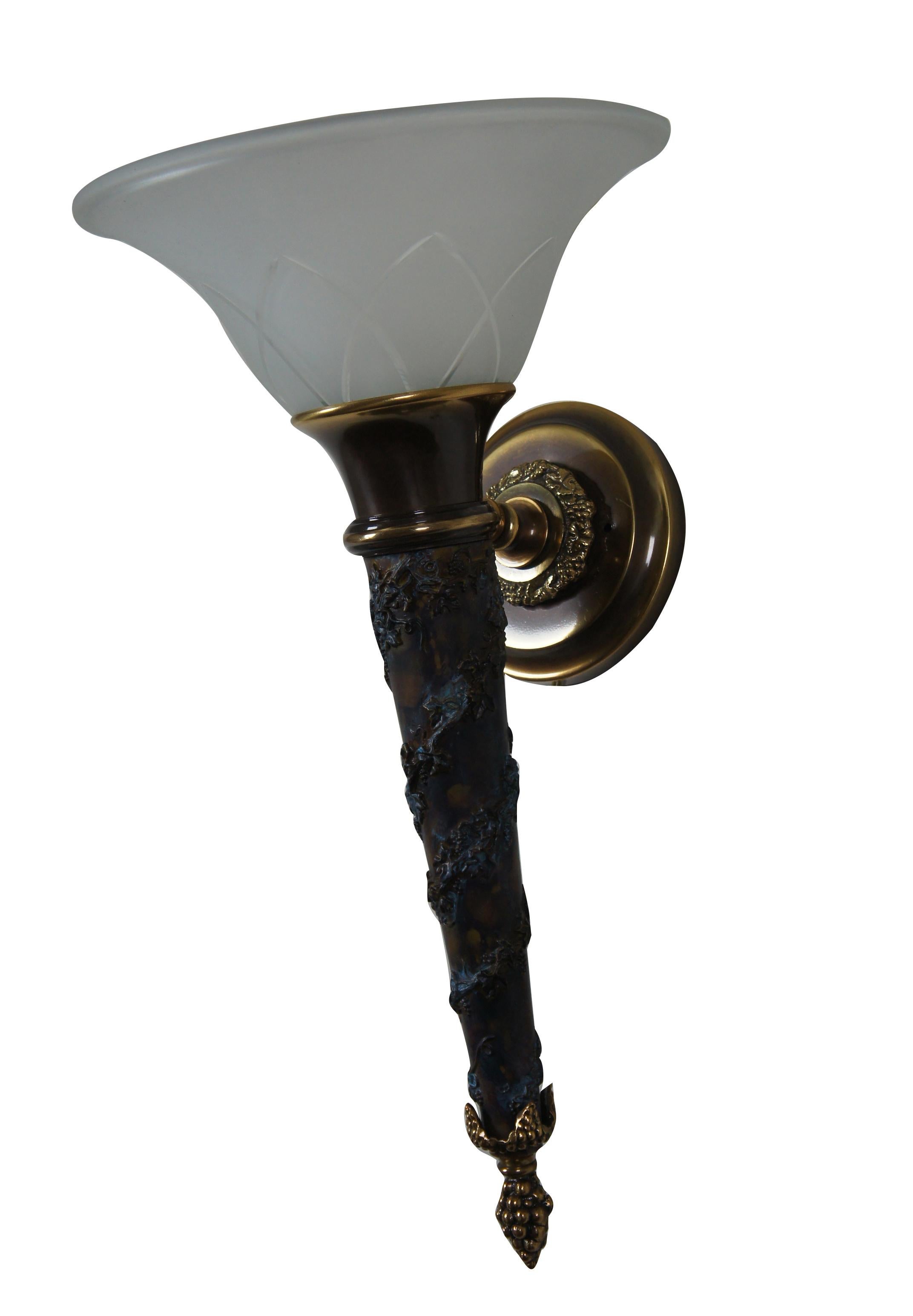 Two monumental French Empire style wall sconce torch lights with frosted glass shade. Made by Minka Lavery. Torch shaped with spiraling design. Made from metal with a brass finish and molded composition center. The lantern is set at any angle, and