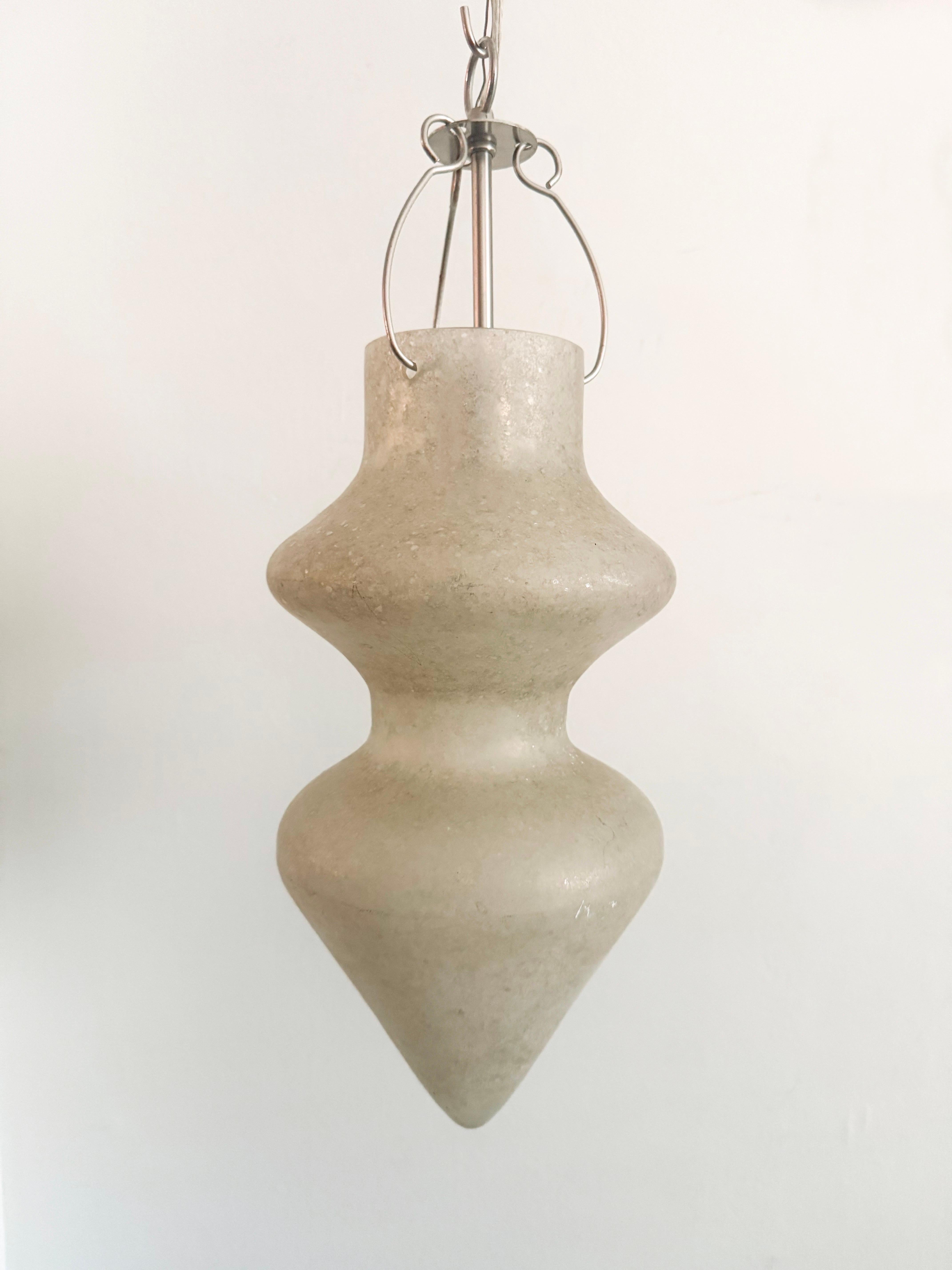 A striking pair of Murano Scavo glass pendant lights designed by Paolo Venini for Vetri Soffiati. Crafted in Italy, these fixtures feature a sculptural double-gourd silhouette with a frosted scavo surface in a soft grey-beige tone, casting a