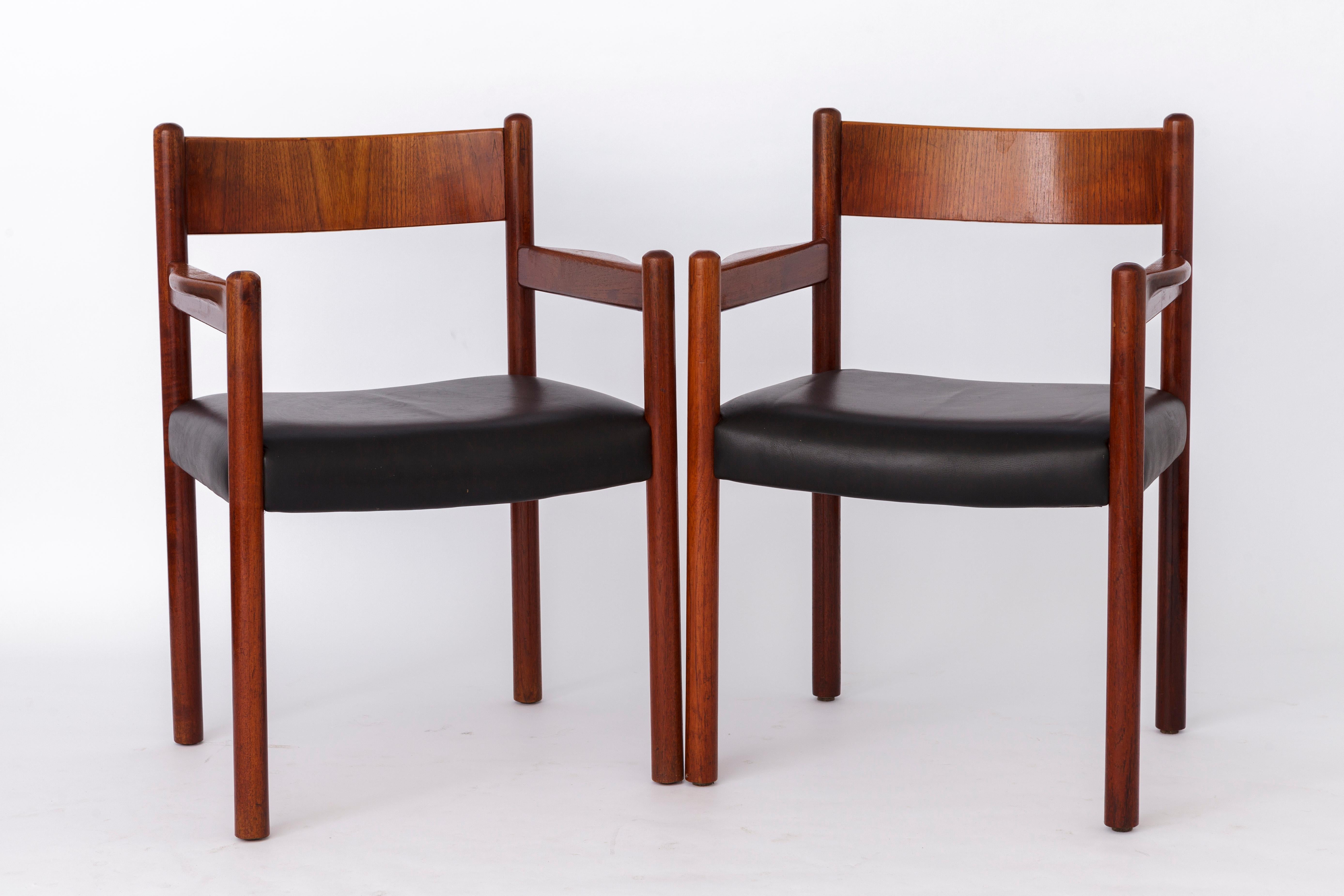 Pair of teak Danish armchairs. Can be used as dining or desk chairs. 
Unknown manufacturer. Origin: Denmark. 
Displayed price is for a pair. Totally up to 12 available. 

Good vintage condition. 
Sturdy, massive teak frame. 
Original black leather