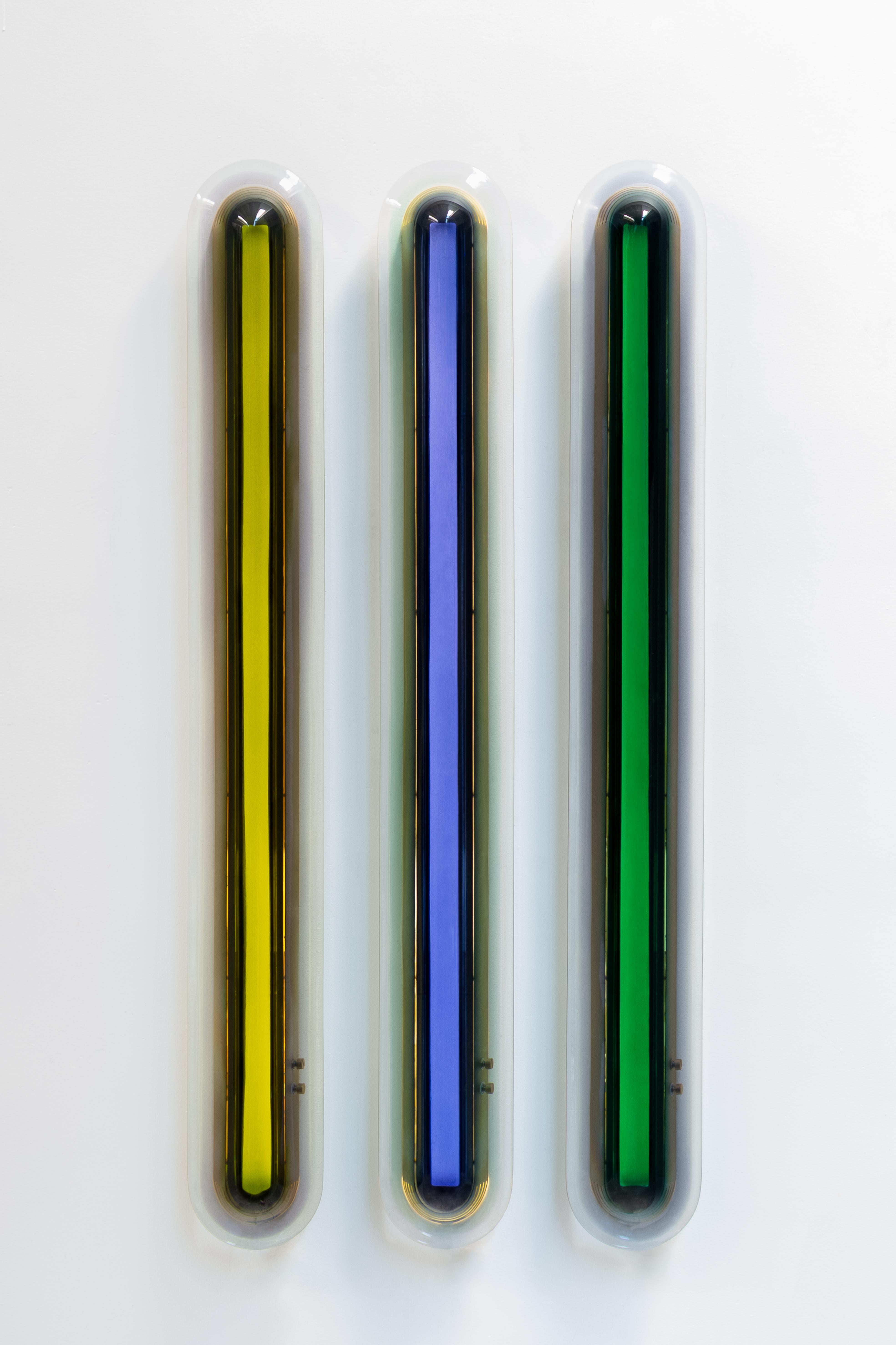 Die vom Weltraumzeitalter inspirierte Wandleuchte Joy entpuppt sich als auffällige Leuchtskulptur. Die leuchtenden Farben werden in unserem Atelier in sorgfältiger Handarbeit durch Aufschichten von Epoxidharz hergestellt, um immer wieder