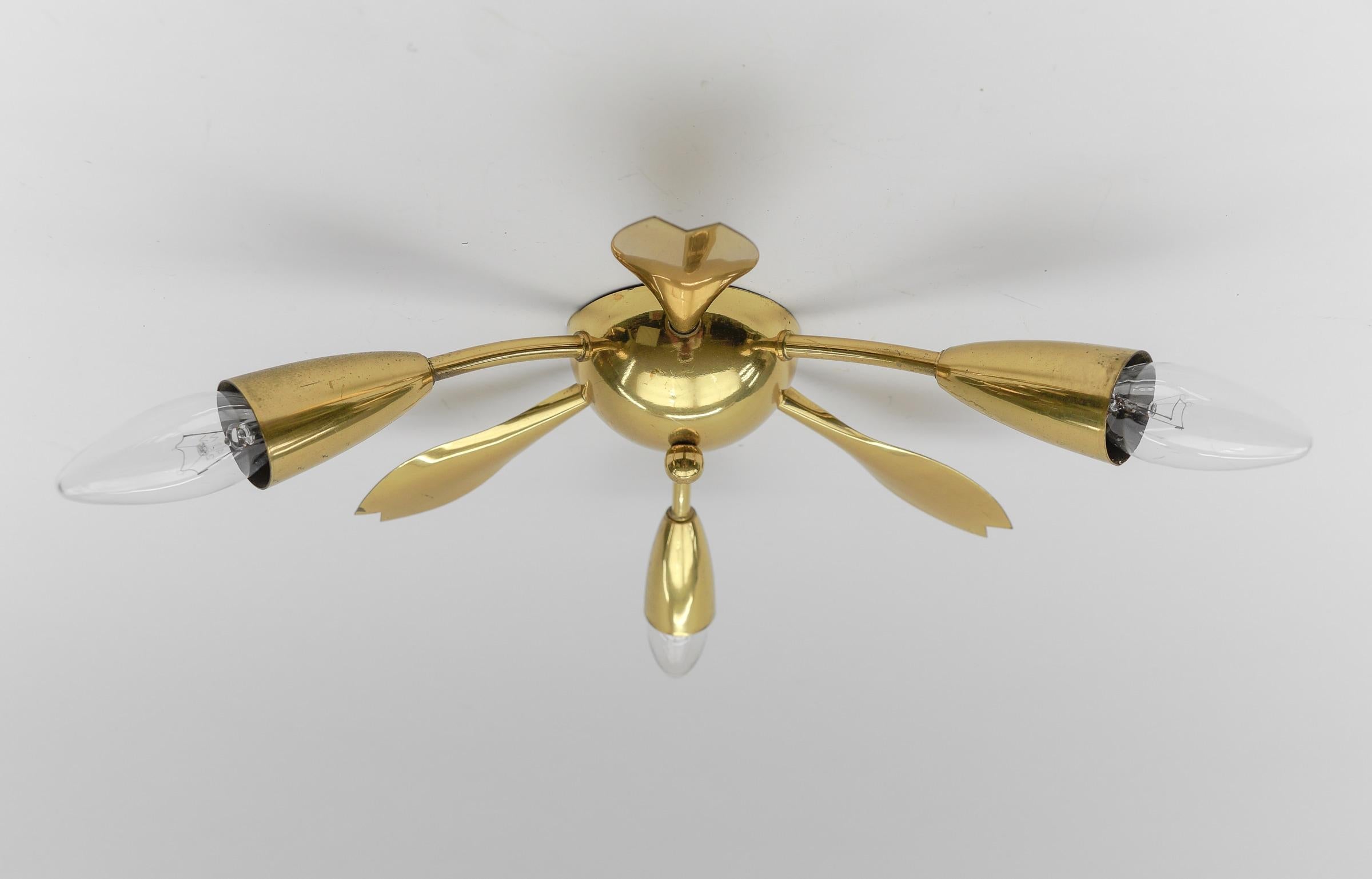 Midcentury 3-armed brass ceiling lamp. In the manner of Arteluce.

Rare and elegant midcentury ceiling lamp, 1950s. Executed in brass and metal.

The lamp is executed with 3 x E14 Edison screw fit bulbs. It is wired and in working condition. It runs