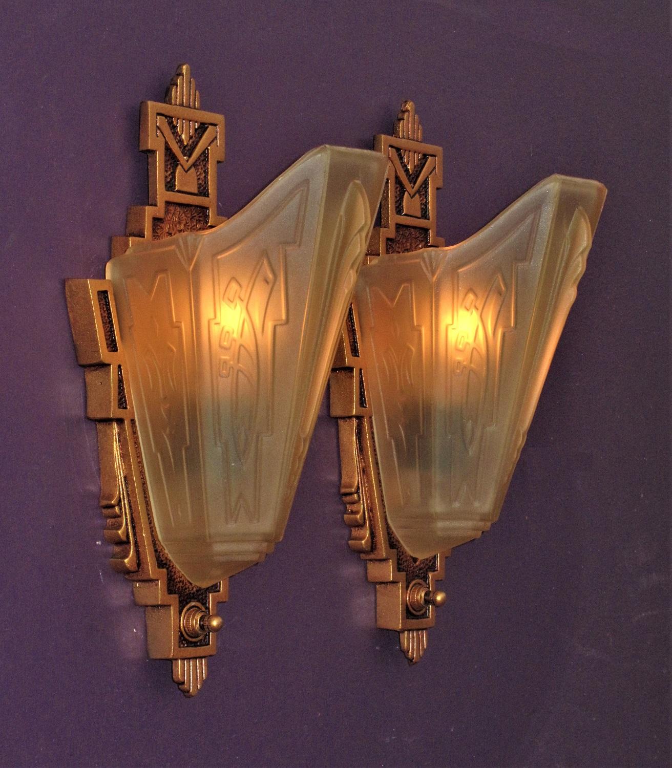 2 pair available, priced per pair.
Late 1920s through mid-1930s wall lighting fixtures with a subtle art deco and American Southwest influences. Highly sought after and prized Consolidated Glass Co. shades adorn these refurbished cast iron sconce