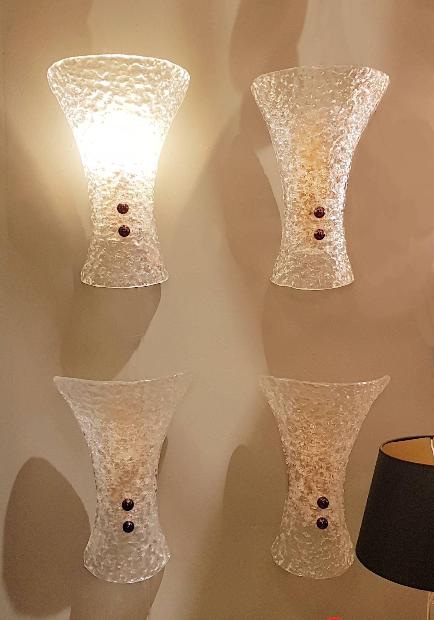 Two pairs of Murano Mid-Century Modern sconces.
Textured clear glass, on the inside surface, with two purple glass screws, on a brass mount.
One candelabra base light each, rewired.
Beautiful quality glass work, in the style of Barovier e