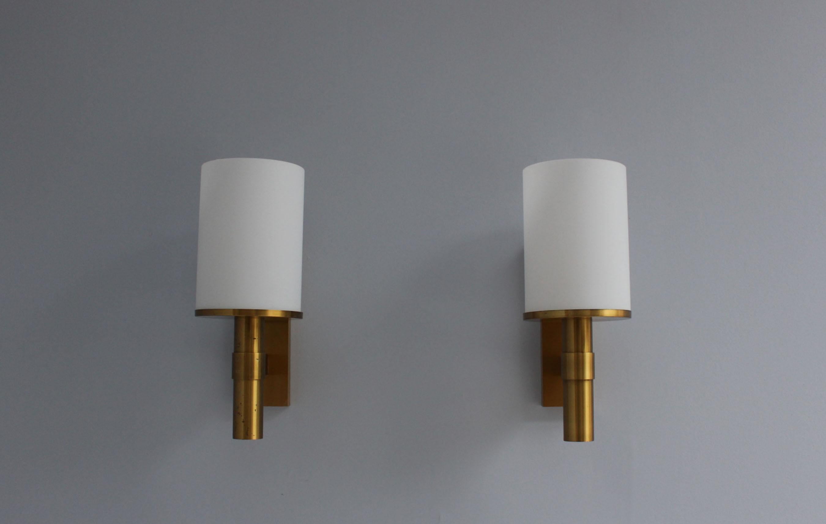 Maison Perzel - A pair of fine French Art Deco wall lights with a bronze base and an enameled glass cylinder shade.
