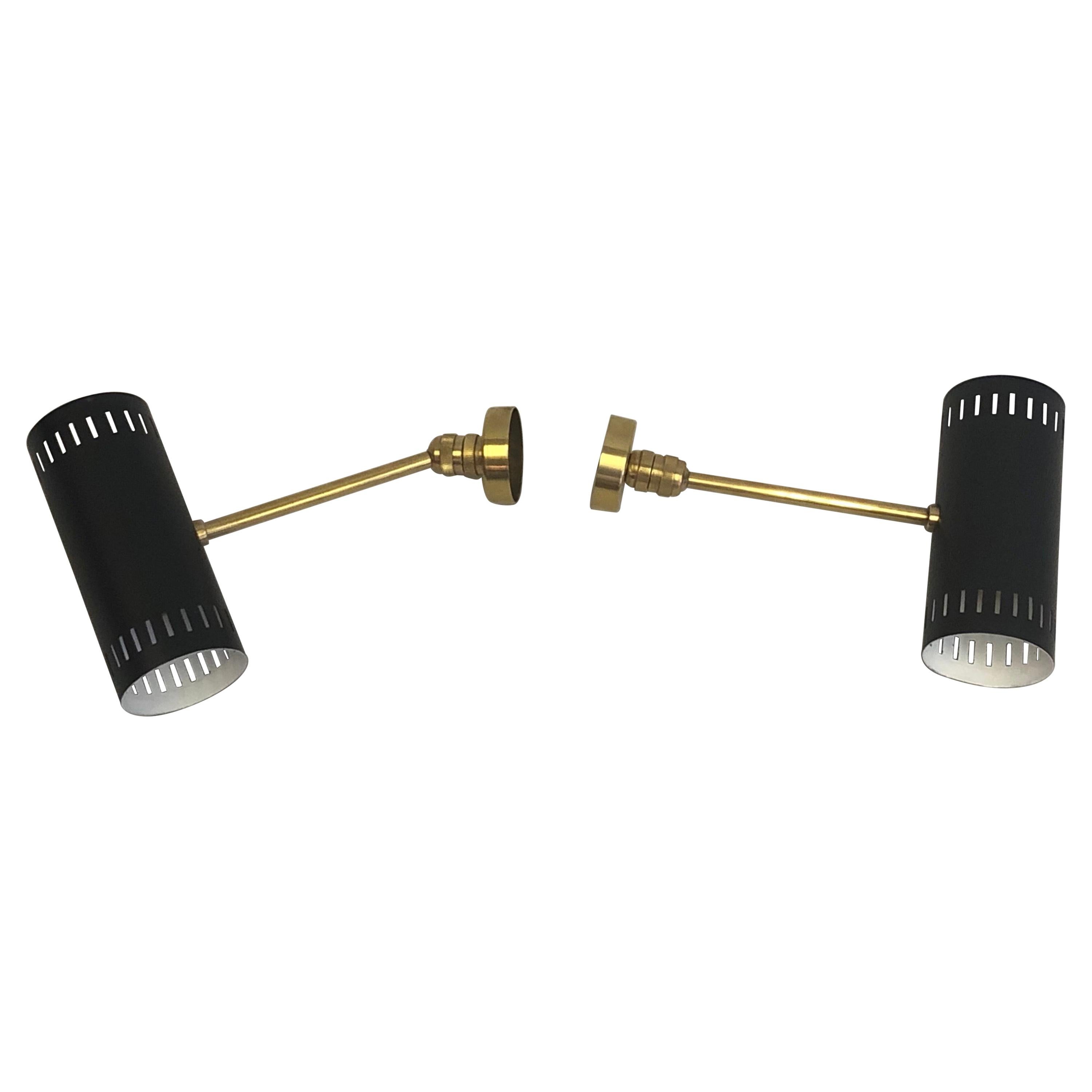 2 pairs of Italian Mid-Century Modern wall sconces / lights by Stilnovo. The sconces reflectors are in black enameled metal with solid brass hardware and pivot to multiple angles to allow one to focus the direction of light. Each reflector has 2