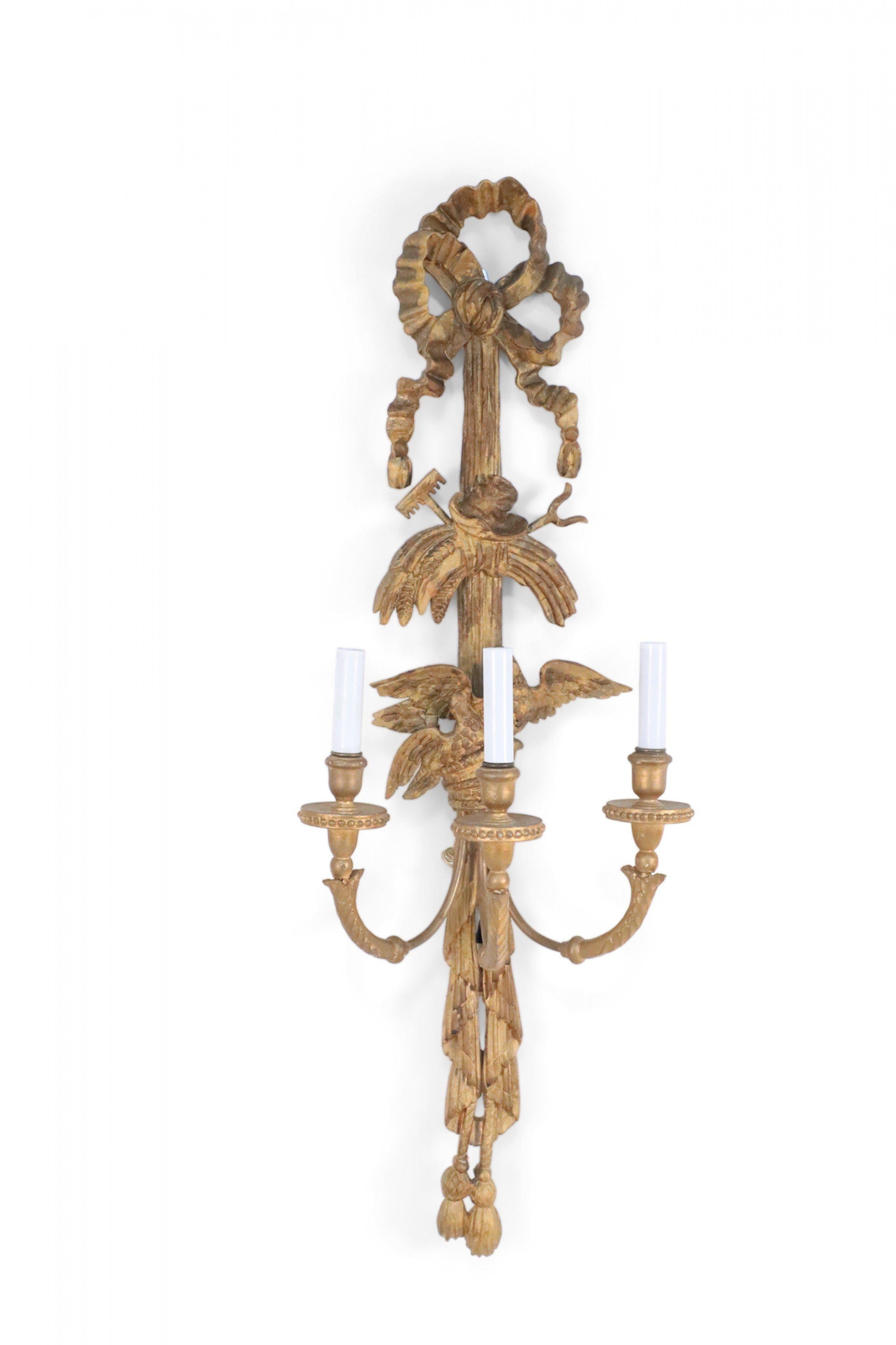 2 paires d'appliques en bois doré de style Louis XVI, sculptées avec des détails complexes tels que des nœuds, des oiseaux et des glands, et contenant trois lumières (PRIX PAR PAIRE).
 