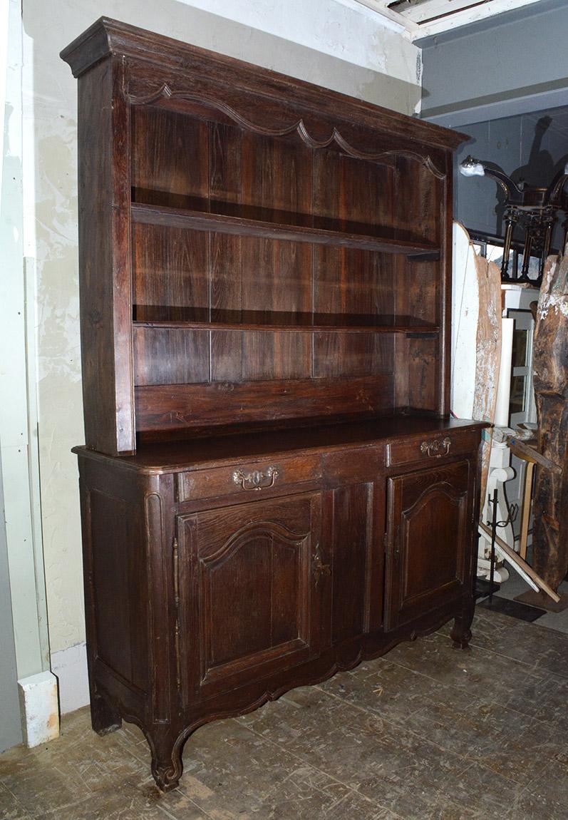 A wonderfully handsome and well proportioned 19th century welsh oak dresser with scalloped decorative cornice, two plate rack shelves, two drawers with brass drawer pulls, two paneled doors, and plank paneled back.
Search terms:  Louis XV French
