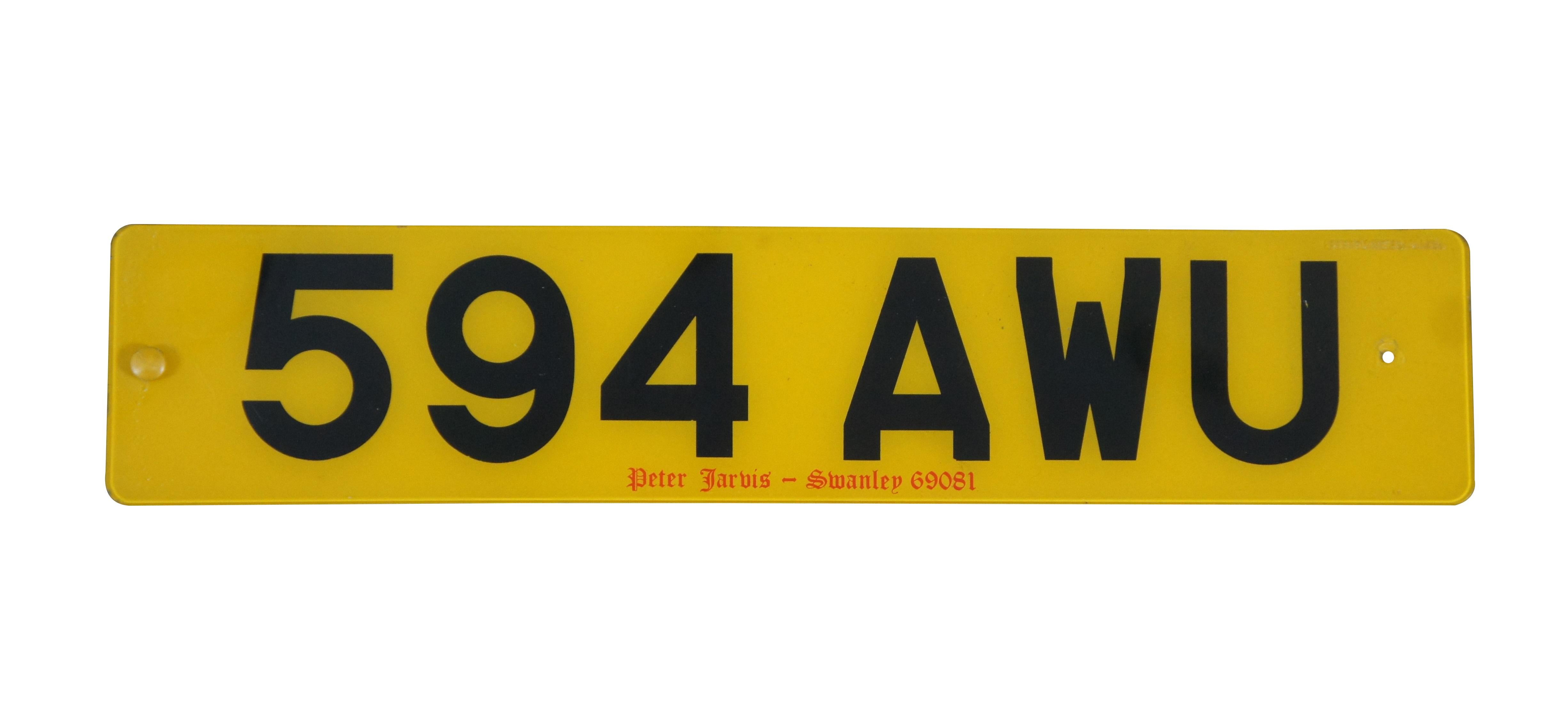 Pair of vintage plastic vehicle registration / license plates from Great Britain, one white and one yellow. Number 594 AWU.  Peter Jarvis - Swanley 69081.

Peter Jarvis is a purveyor of classic cars based in Swanley, Kent,