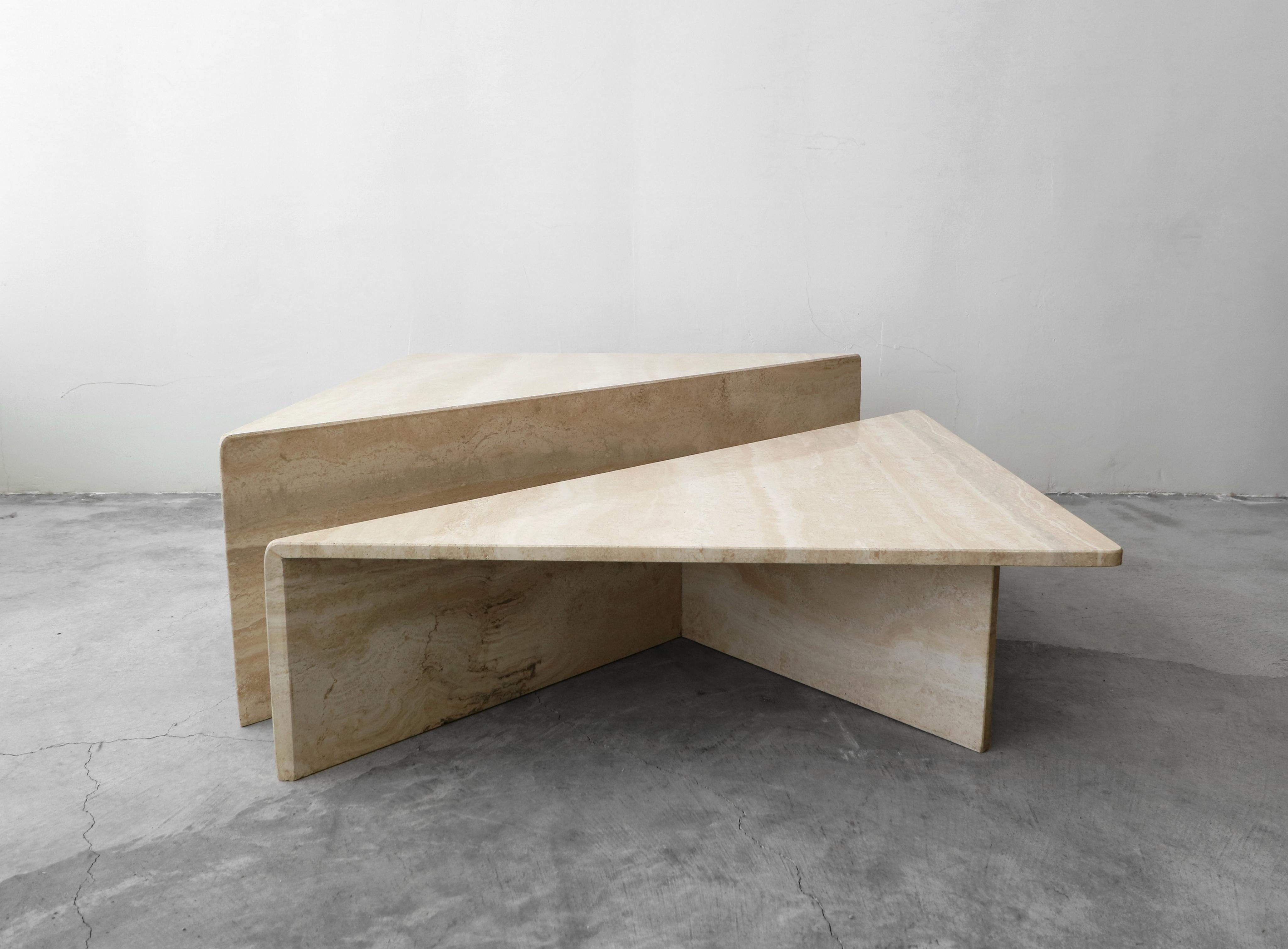 Classic Postmodern tiered Italian travertine coffee table. Simple beautiful piece. Table is of modernist and minimal design, comprised of 2 triangular tables of different heights, they can be configured in any manner to form a square or a rectangle,