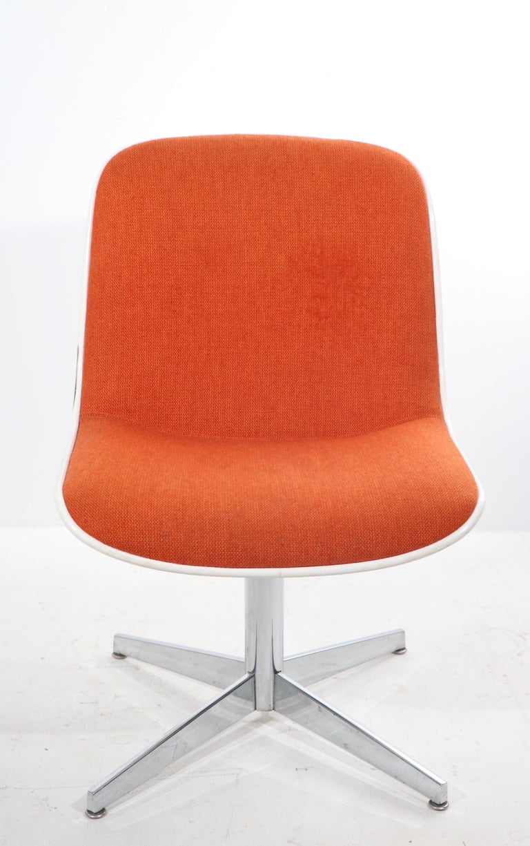 Chic architectural side chair by noted American furniture maker, Steelcase. The chair features an orange tweed continuous seat and back, with white plastic exterior shell, on chrome pedestal, with four wheel casters. It is in very good, original