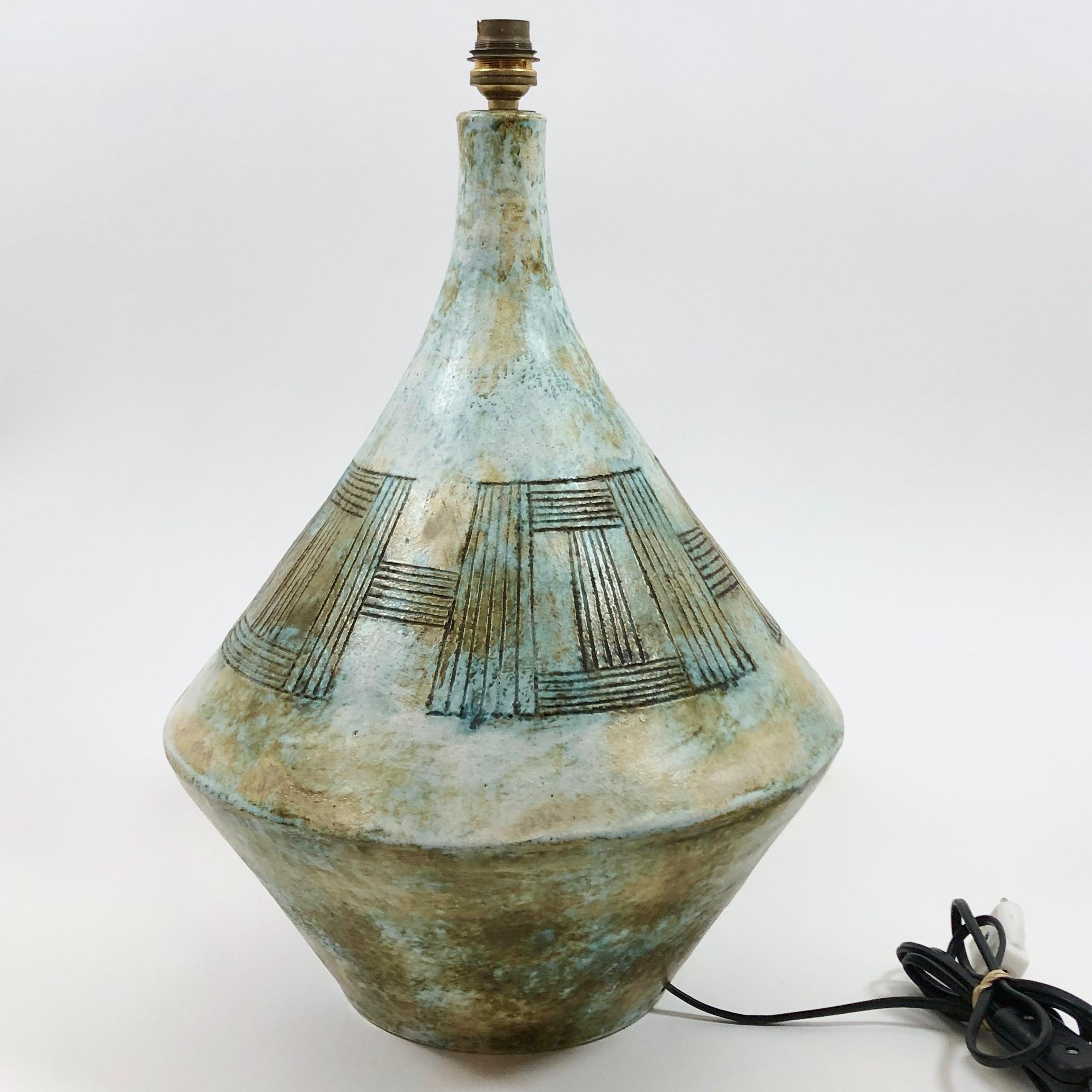 Hand-thrown pottery artwork, forming table lamp base, ceramic enameled in shades of cloudy pale brown, blue, and beige, decorated with geometric designs incised and blackened on all sides.
Ceramic signed by the French ceramicists 2 potiers (Deux