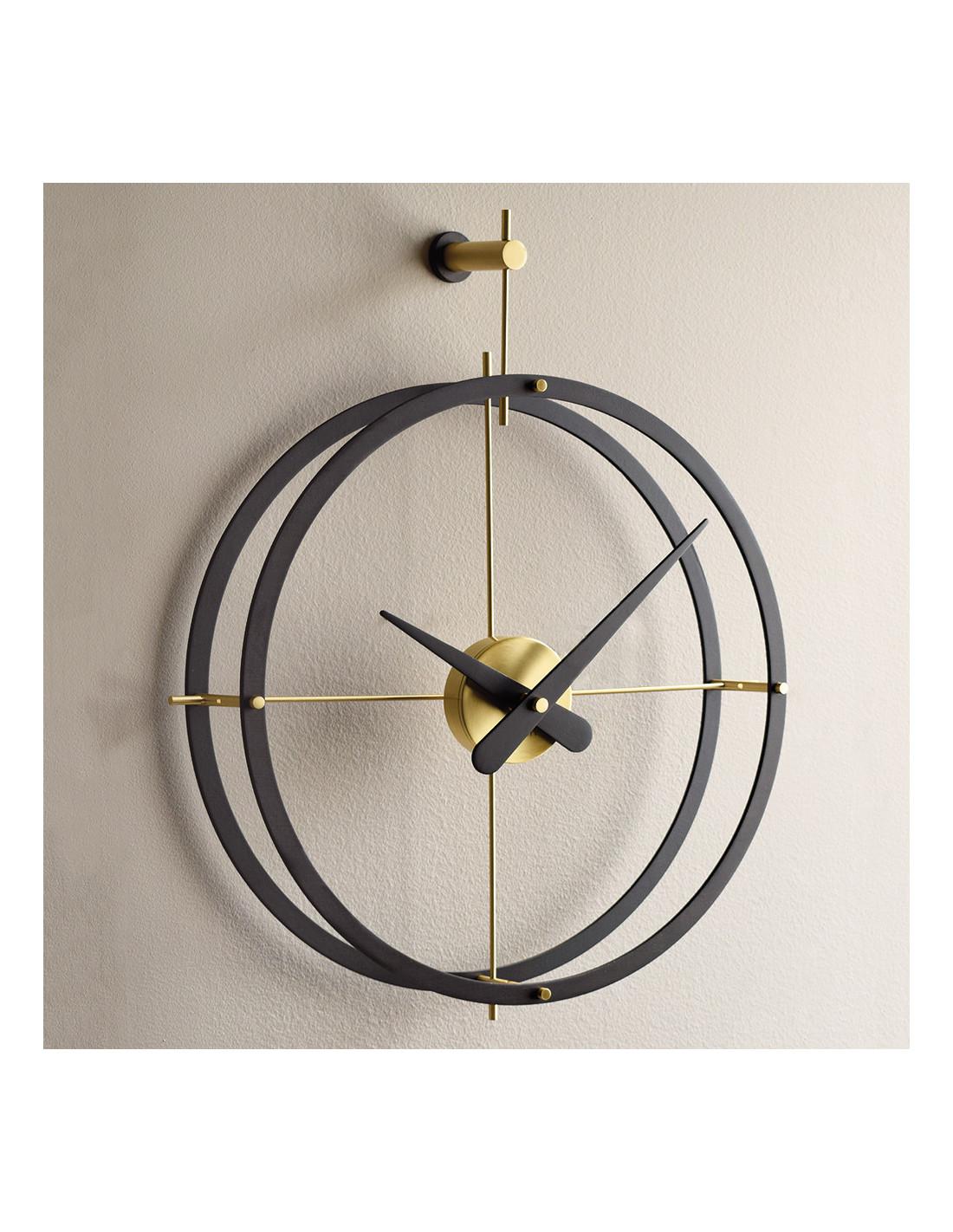 This is a wall clock with a double wooden ring, gold box and wooden needles. The mechanism is covered by the case made of polished brass. 
2 puntos NG wall clock : Rings and hands in wenge finished wood, box in polished brass.
Not OK for Outdoor