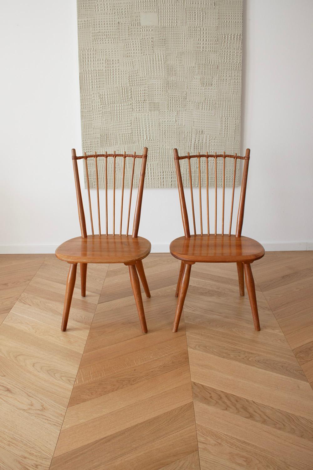 This rare set of 2 dining chairs are designed by Albert Haberer and manufactured by Hermann Fleiner, Germany in ca 1950. These chairs are beautifully crafted with attention to detail. The backrest spindles are skillfully connected with a leather