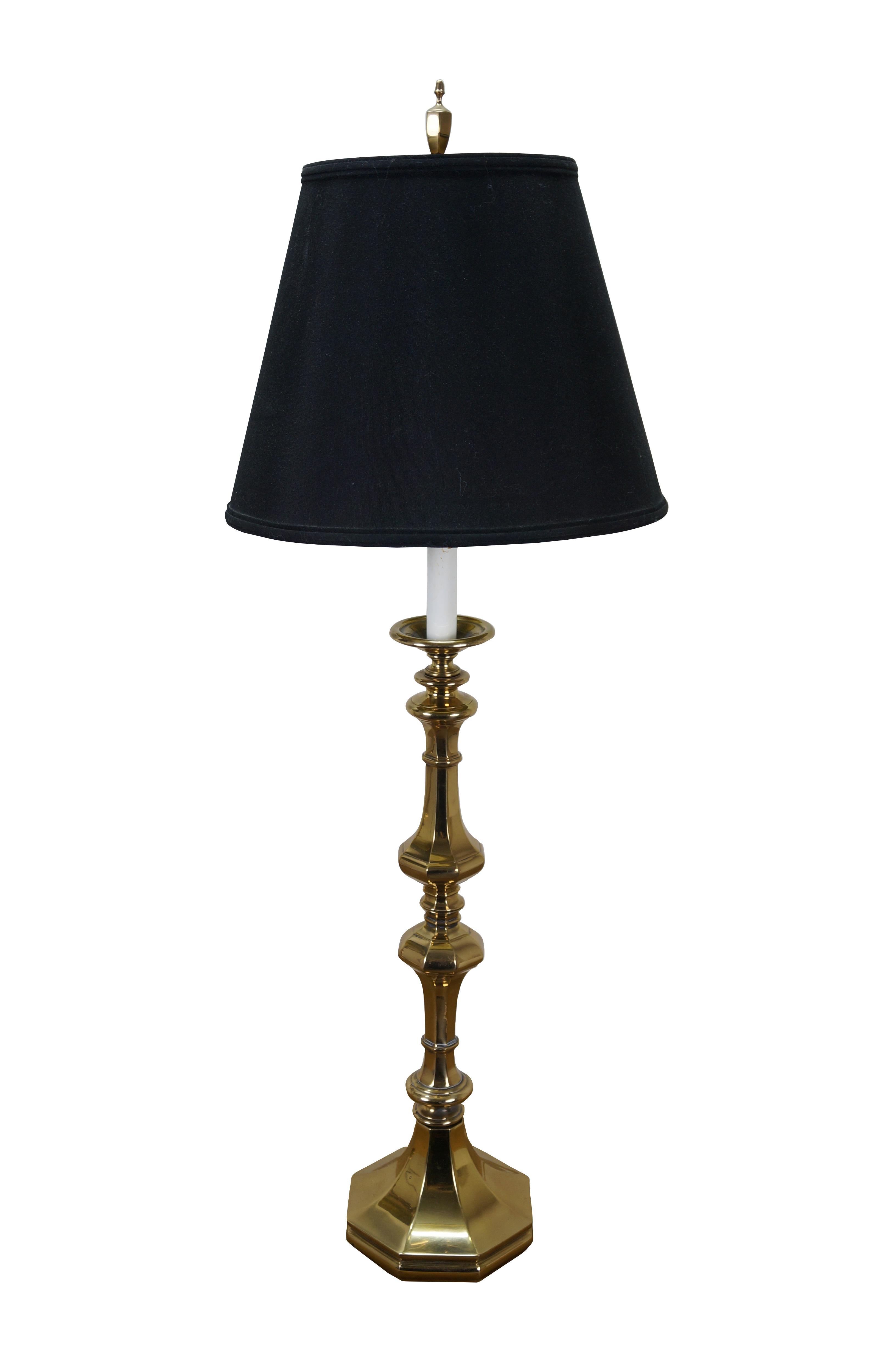 Pair of very large and impressive Rembrandt Lamps Masterpieces Lamps.  They feature Hollywood Regency and colonial styling with tall polished brass candlesticks and faux candle tops. Includes harps, urn shaped brass finials, and black shades with