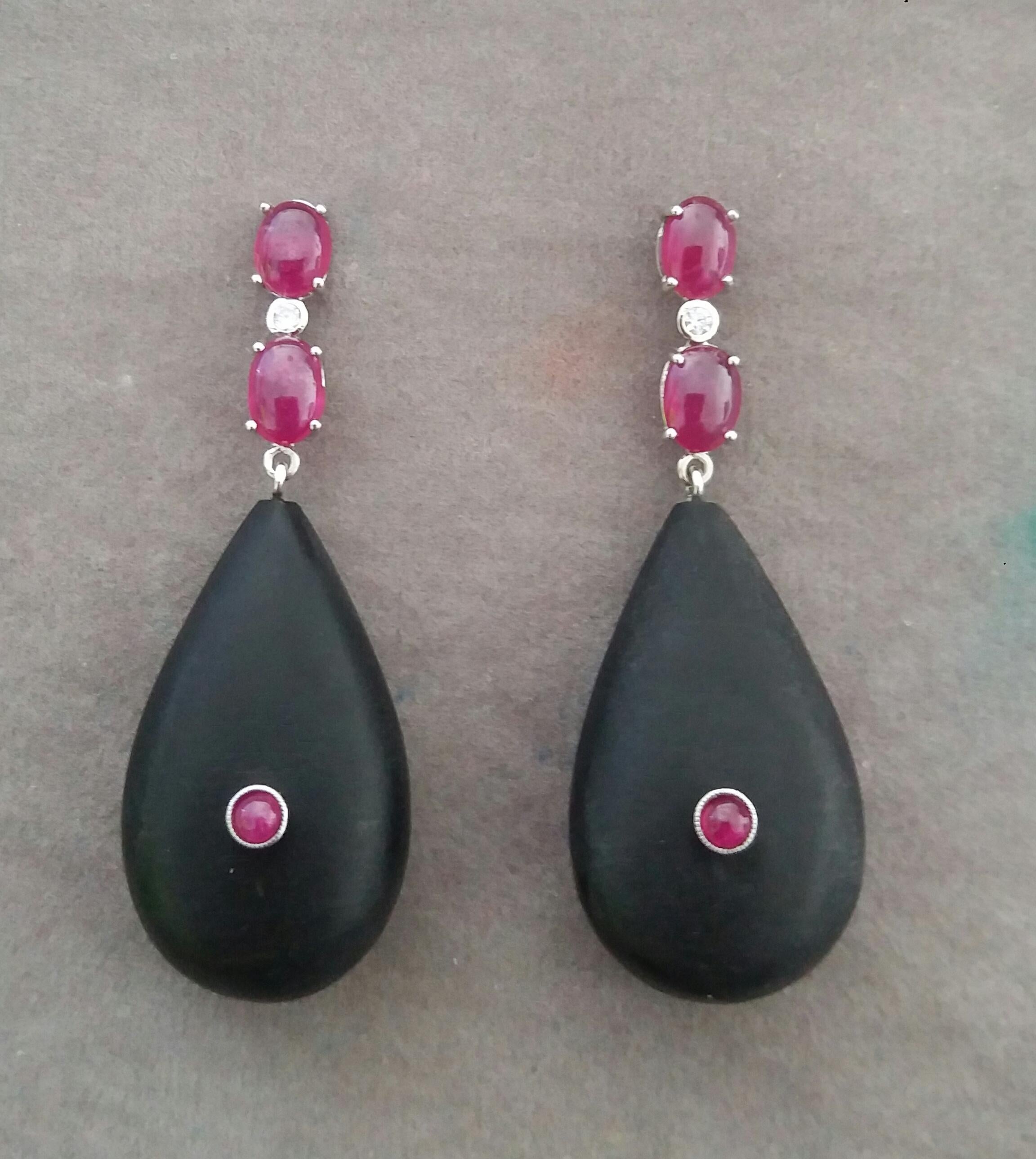Elegant and completely handmade Earrings consisting of an upper part of 2 oval shape Ruby cabs of 4 mm x 5 mm set together in 14 Kt white gold with a  small diamond in the middle, at the bottom 2 Natural Ebony Plain Drops measuring 18 x 30 mm with a