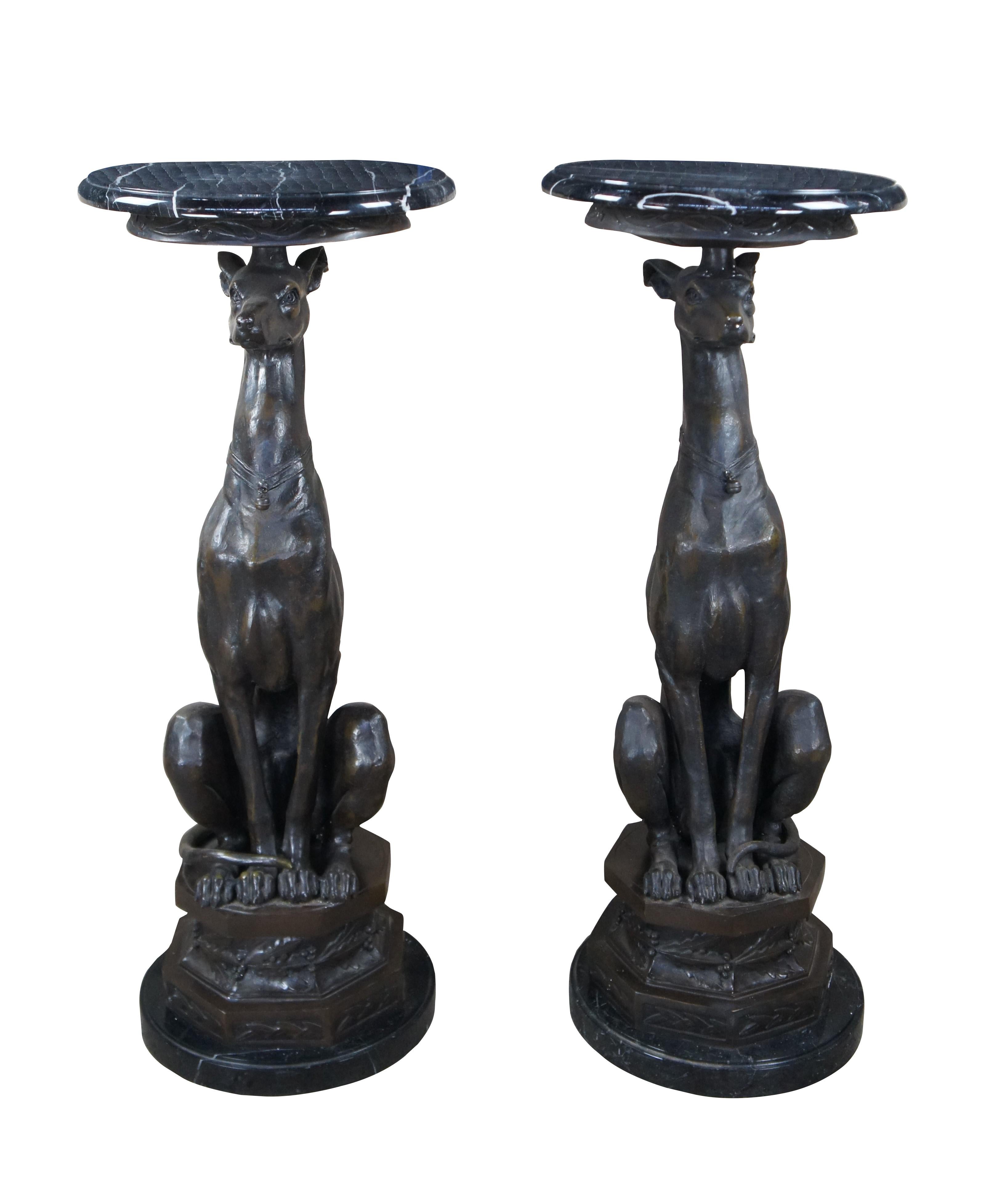 Pair of Bronze Sculpture Pedestals After Pierre Jules Mene, Attributed to Maitland Smith. Circa late 20th Century. Features a round marble top over a figural Whippet / Greyhound Sculpture. The dogs are seated on a plinth with a leaf and berry motif