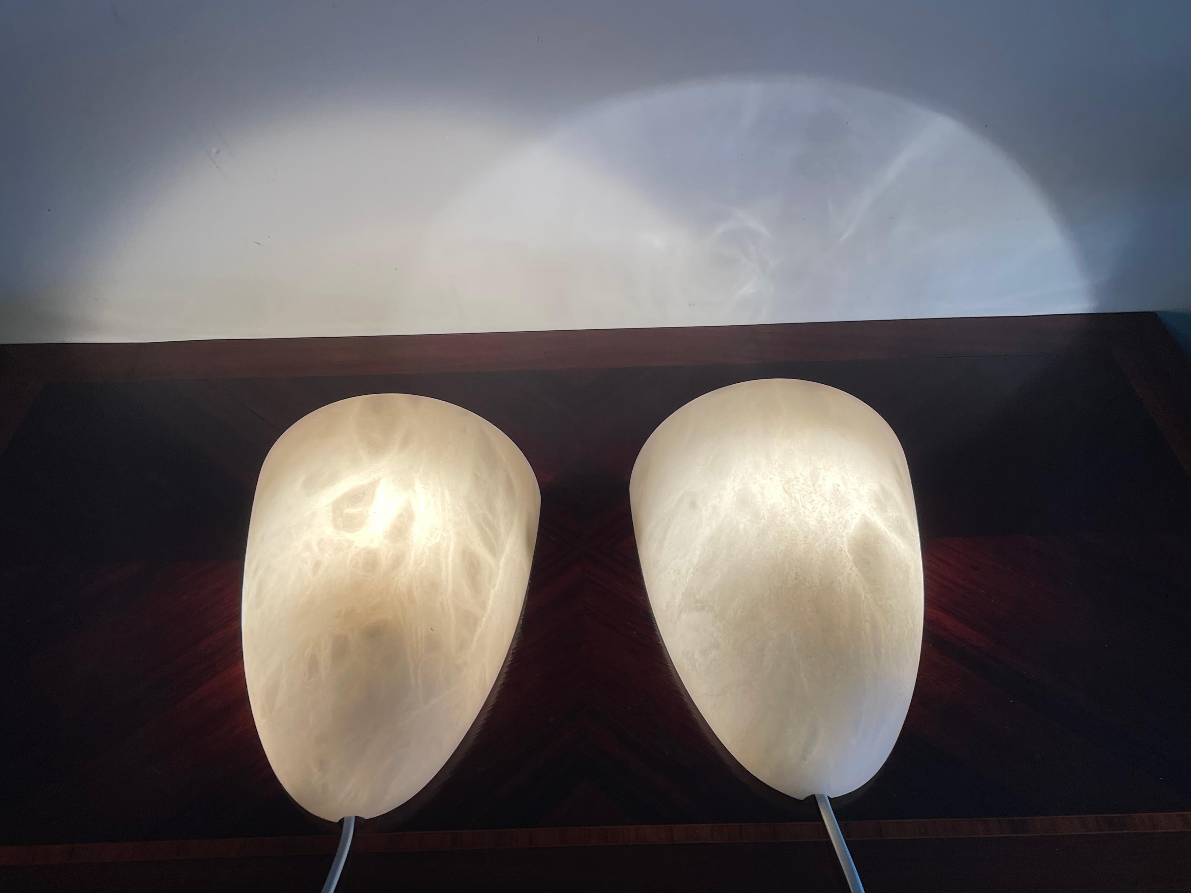 Two handcrafted and very stylish pairs of midcentury made alabaster wall lights.

If you are looking for a great shape and practical size pair (or two pairs) of sconces to grace your living space then these natural mineral stone fixtures could be