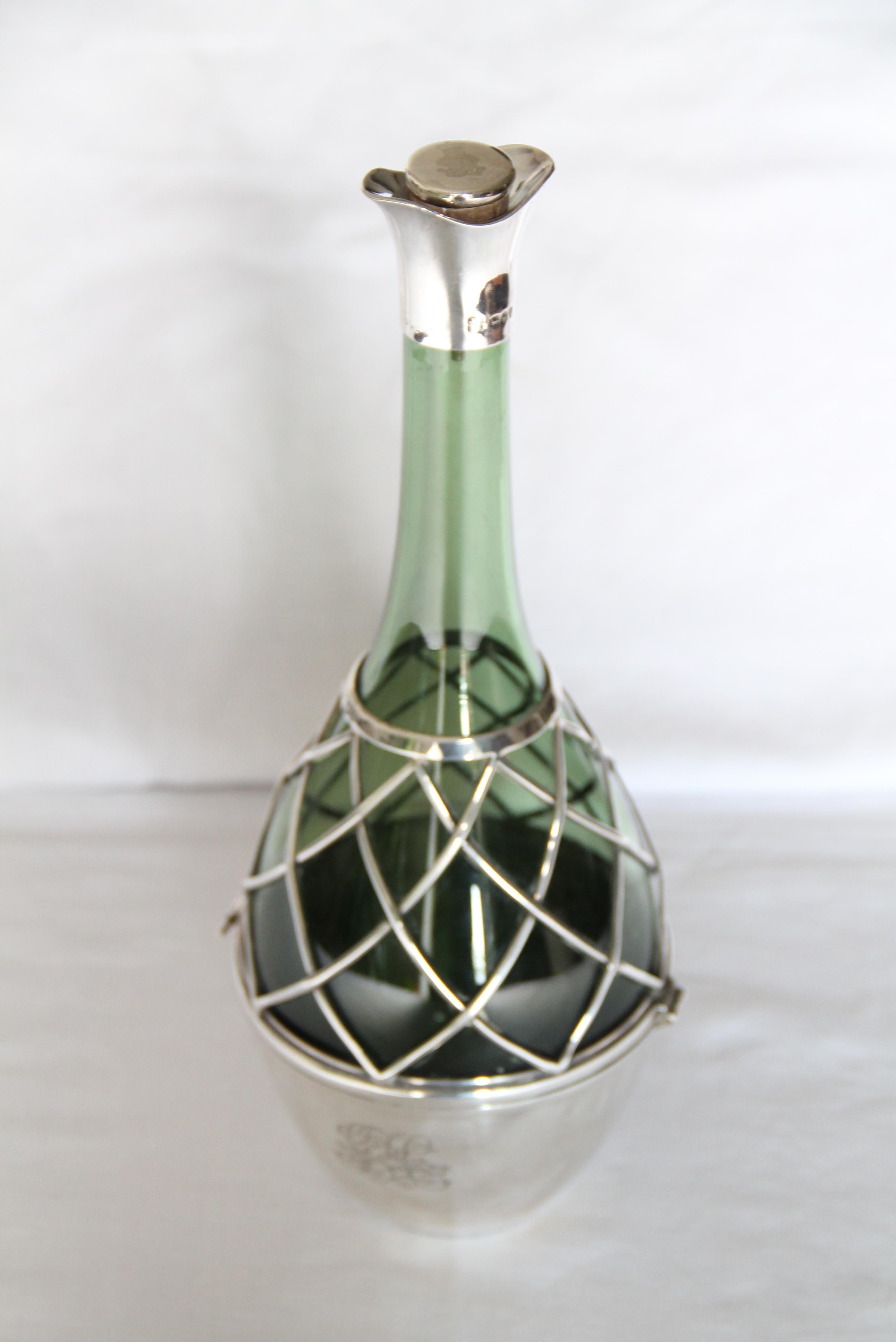 A pair of unique late Victoria silver mounted green glass carafes, John Aldwinckle & James Slater, London ,1894,club form, each body encased with a cup and lattice-work, double lipped neck mount and silver capped cork stopper, engraved with a 'G'