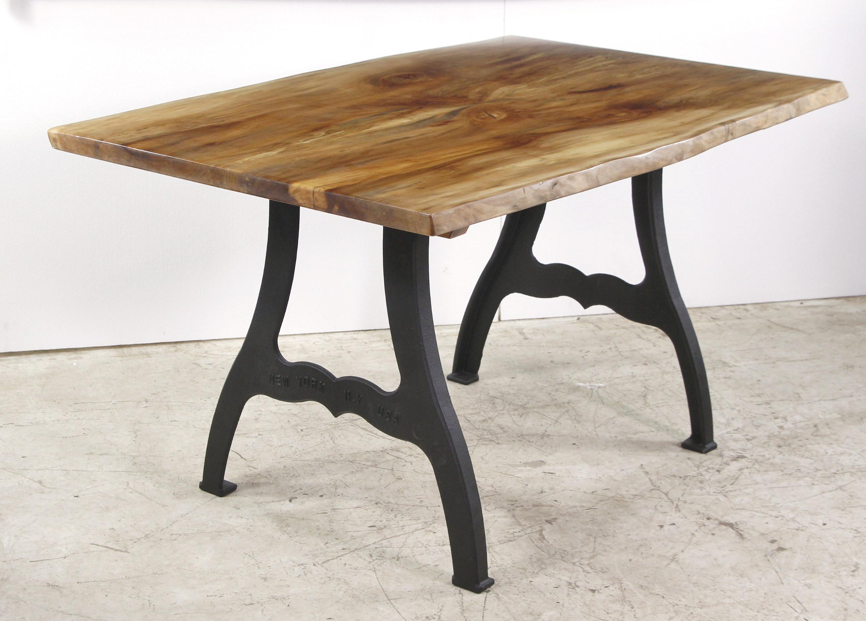 Newly made live edge maple table top featuring 2 slab construction giving an open book matched look and an Organic Modern feel. Paired with Industrial cast iron legs that say New York, NY embossed on them. This can be seen at our 400 Gilligan St